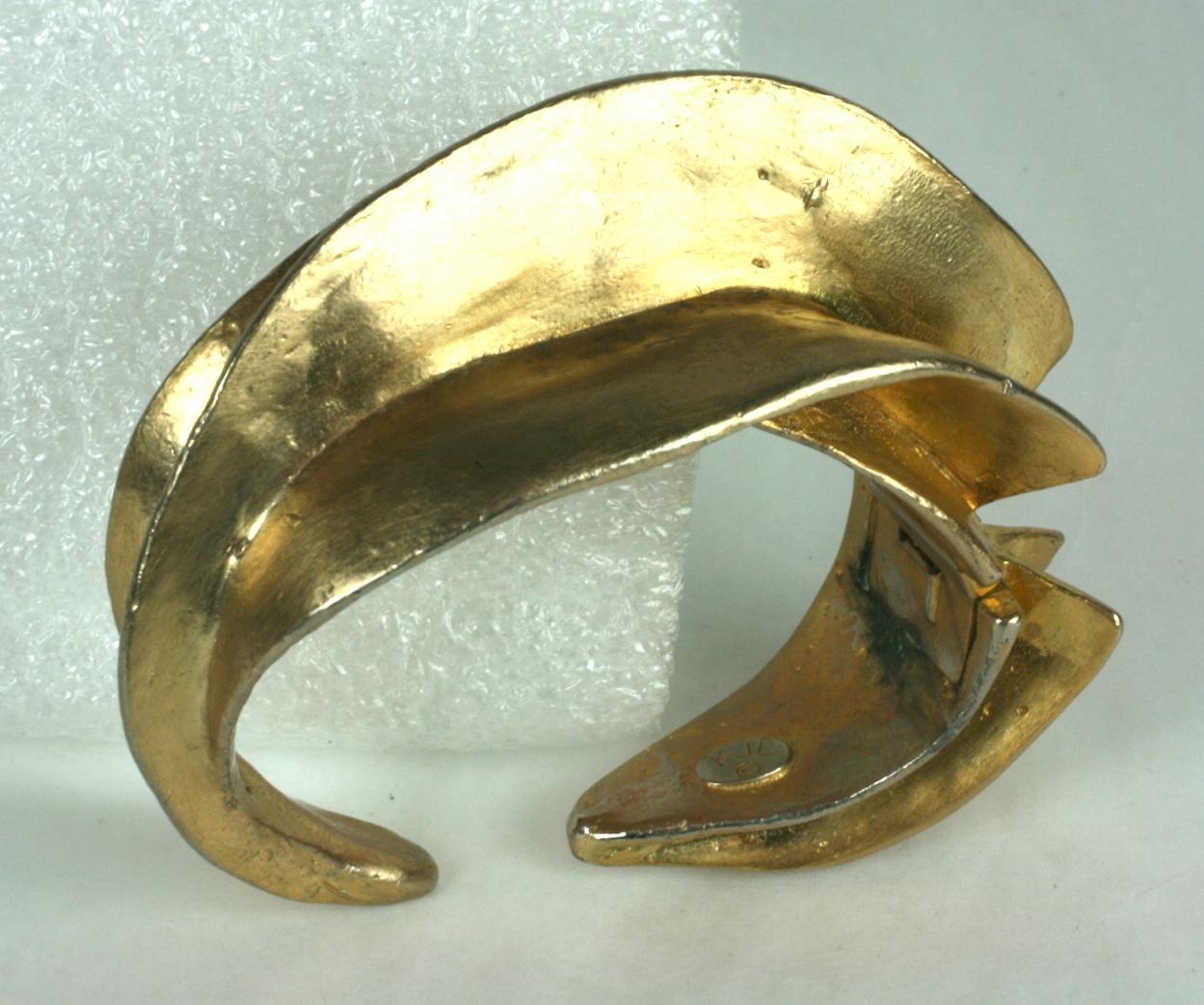 Kenneth Jay Lane Ethnic inspired patinaed gilt cuff with clamp hinged closure. Dimensional swirl design looks incredibly sculptural and modern when worn. It can be worn in different ways and looks different from every angle.
1.25