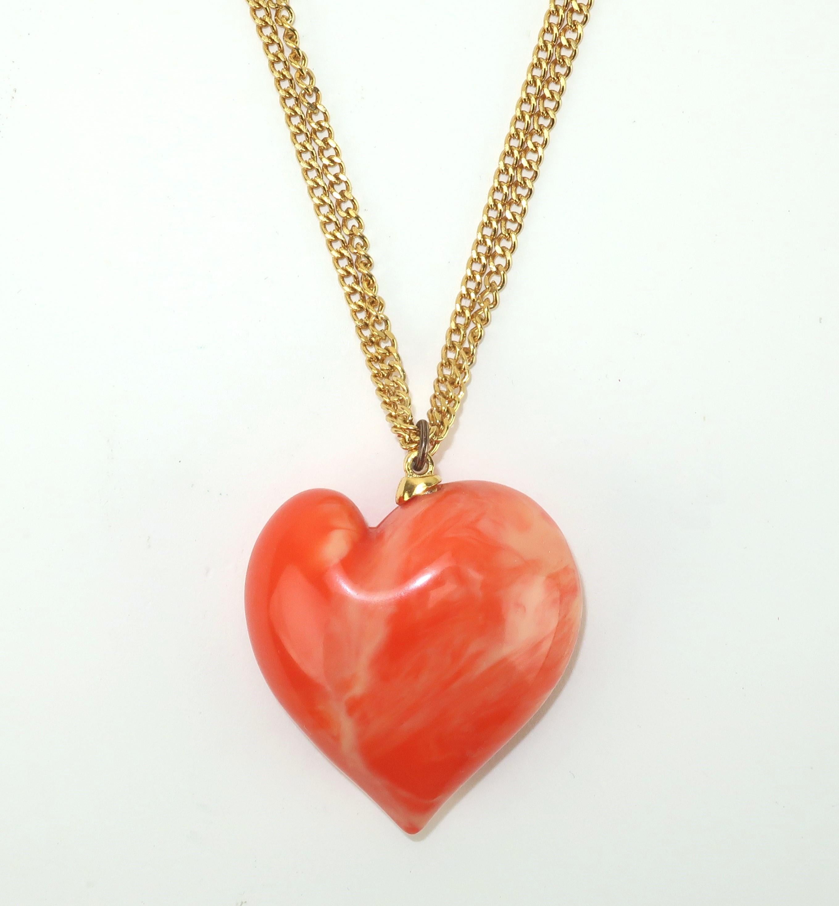 1980's Kenneth Jay Lane pendant necklace with doubled gold tone link chain.  The large heart shaped resin pendant is a real stand out in a vibrant coral color with a marbleized effect.  The long chain is outfitted with a spring ring safety catch and