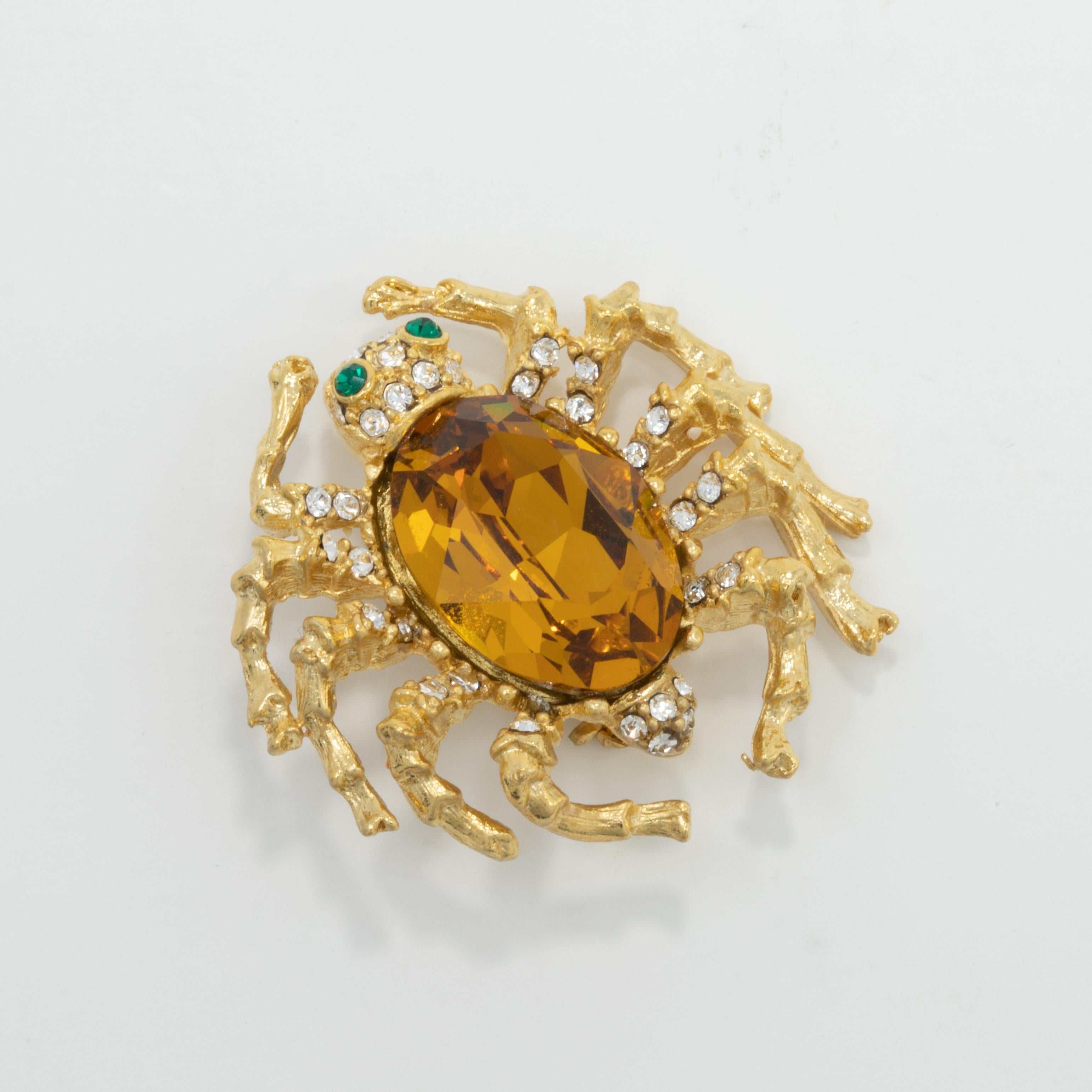 Dazzling Kenneth Jay Lane brooch. This golden spider is decorated with small emerald and clear crystals, and a large amber crystal center.

Tags, Marks, Hallmarks: Kenneth Lane