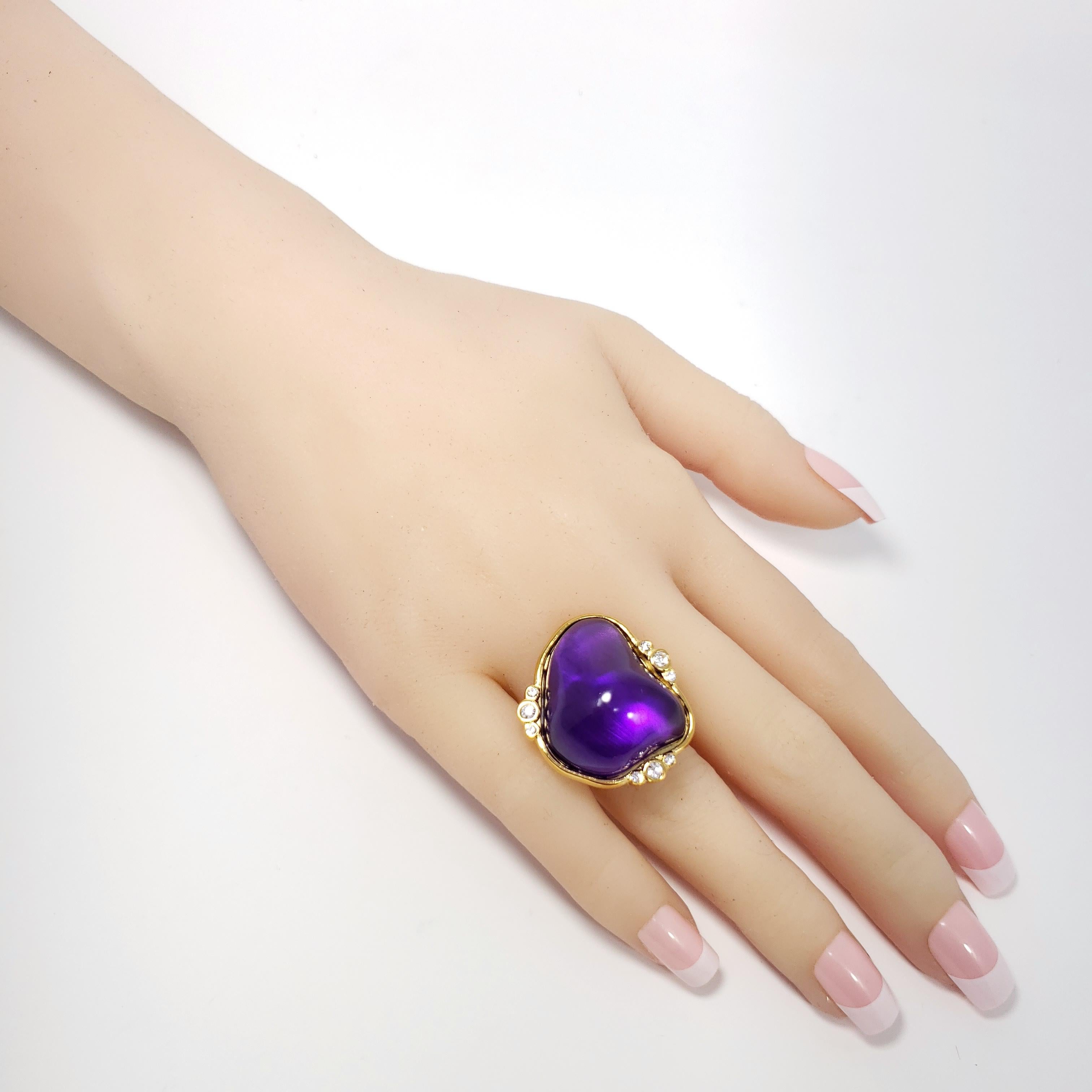 A bold cocktail ring by Kenneth Jay Lane, featuring a vibrant purple cabochon accented with clear crystals. Set in a gold-plated bezel.

Adjustable sizes 5 to 8.5 

Tags, Marks, Hallmarks: Kenneth Lane, Made in USA