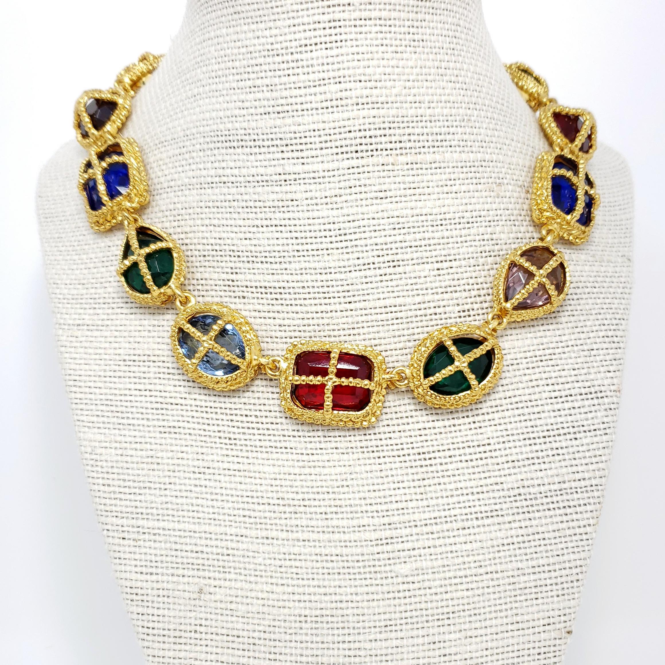 Big bold jewels sit in open-back gold-plated settings in this colorful Kenneth Jay Lane necklace!

Crystals: Ruby, Sapphire, Amethyst, Emerald

Gold plated.

Tags, Marks, Hallmarks: Kenneth Lane

Length: 15.5 inches + 3 inch extension chain