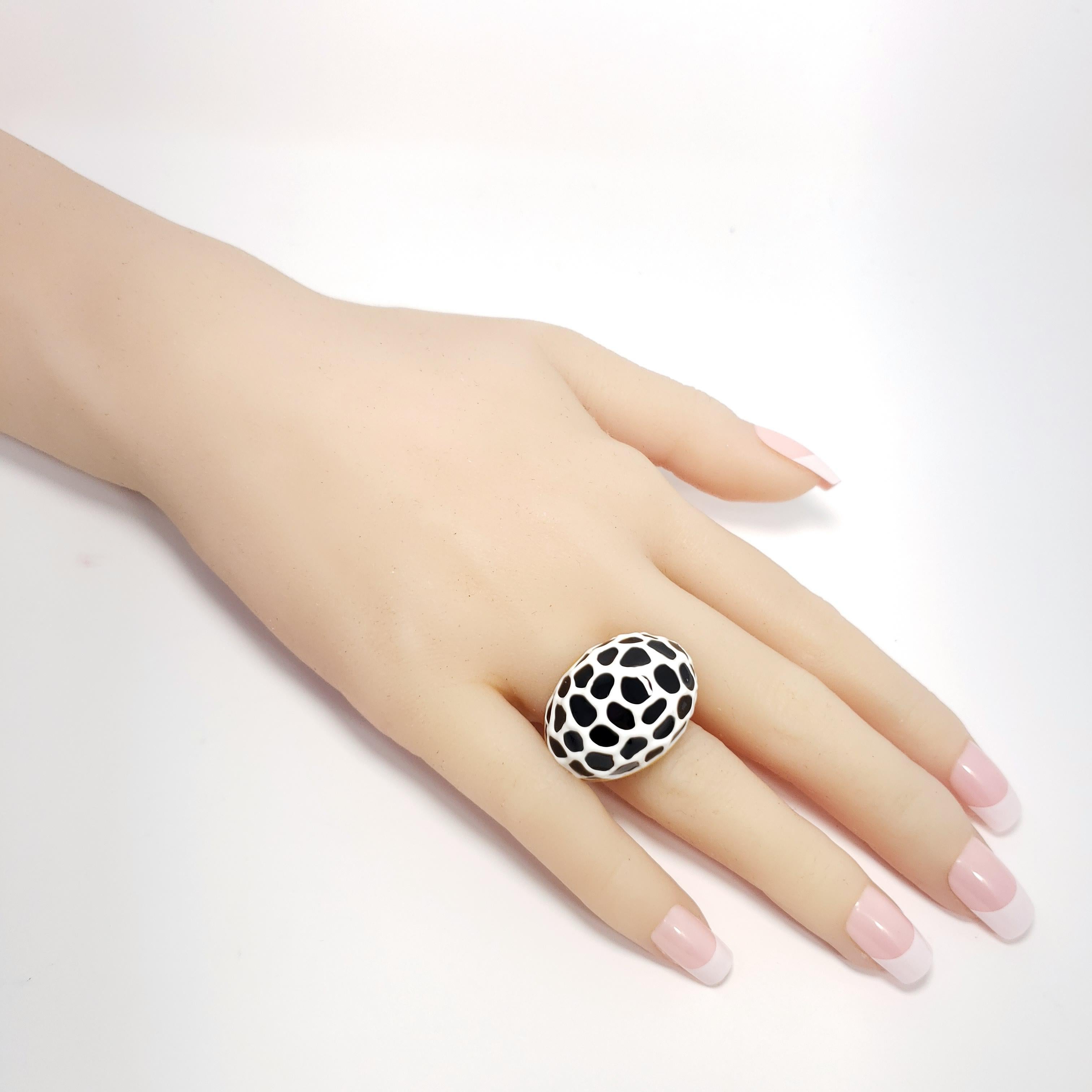 Cocktail statement ring by Kenneth Jay Lane, featuring decorative black and white enamel painted on a raised dome band.

Gold-plated.

Adjustable sizes 5 to 8.5 

Tags, Marks, Hallmarks: Kenneth Lane