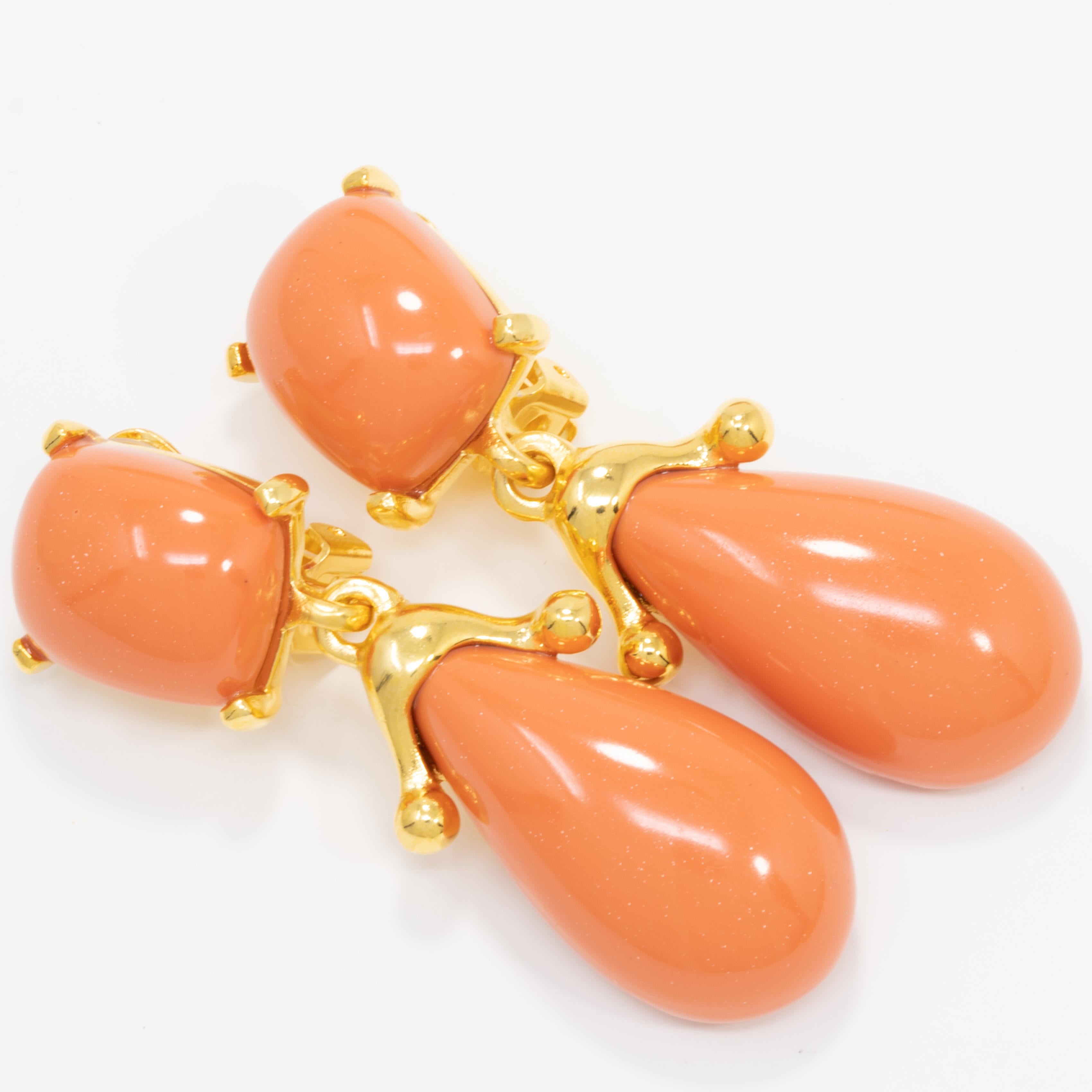 A coral cabochon prong-set in a gold clip on earring, with a dangling tear-shaped cabochon. A stylish pair of Kenneth Jay Lane earrings to accentuate any outfit!

Hallmarks: KJL, Made in USA