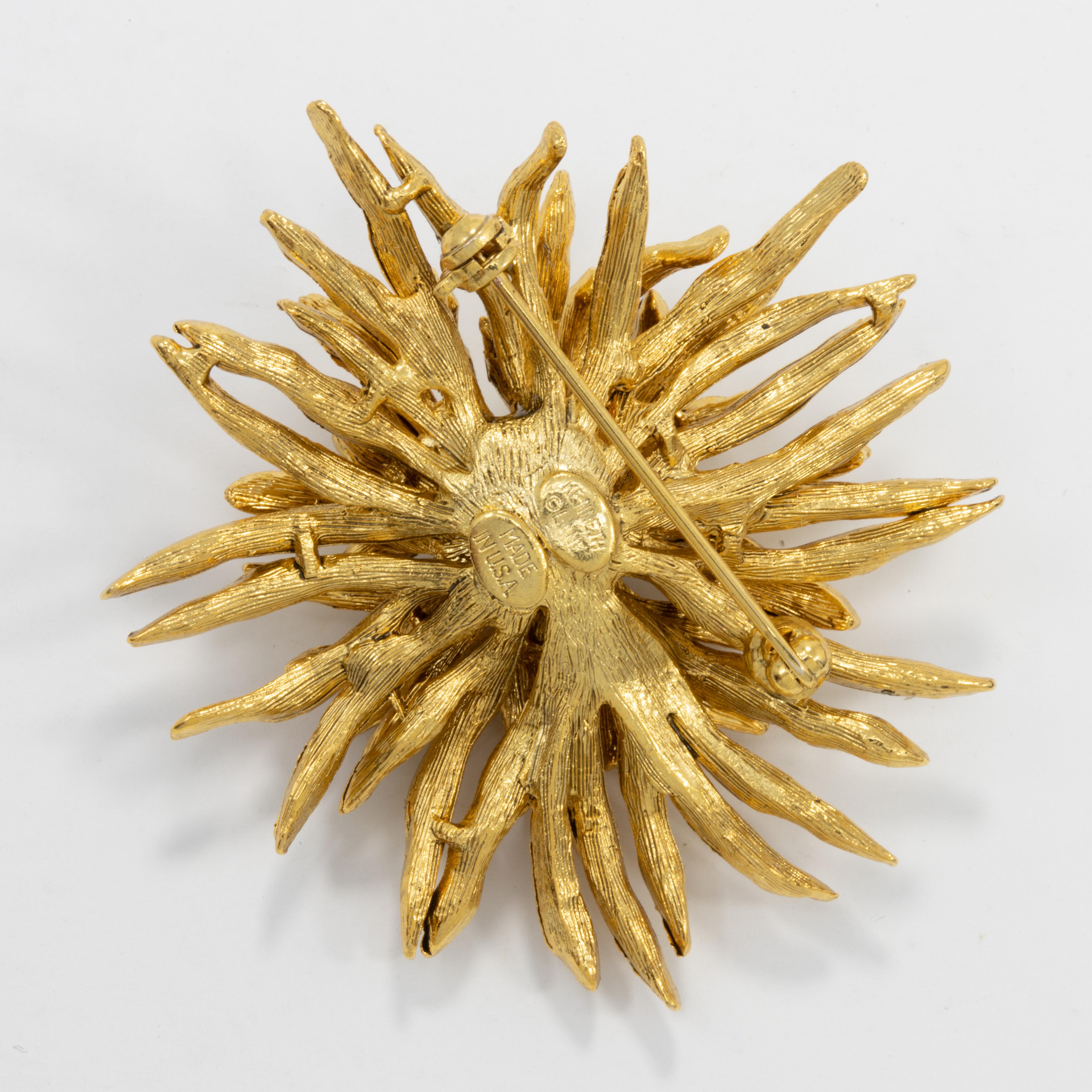 Glamorous golden flower decorated with clear crystals. A stylish pin brooch by Kenneth Jay Lane!

Marks / hallmarks / etc: Kenneth Lane, Made in USA