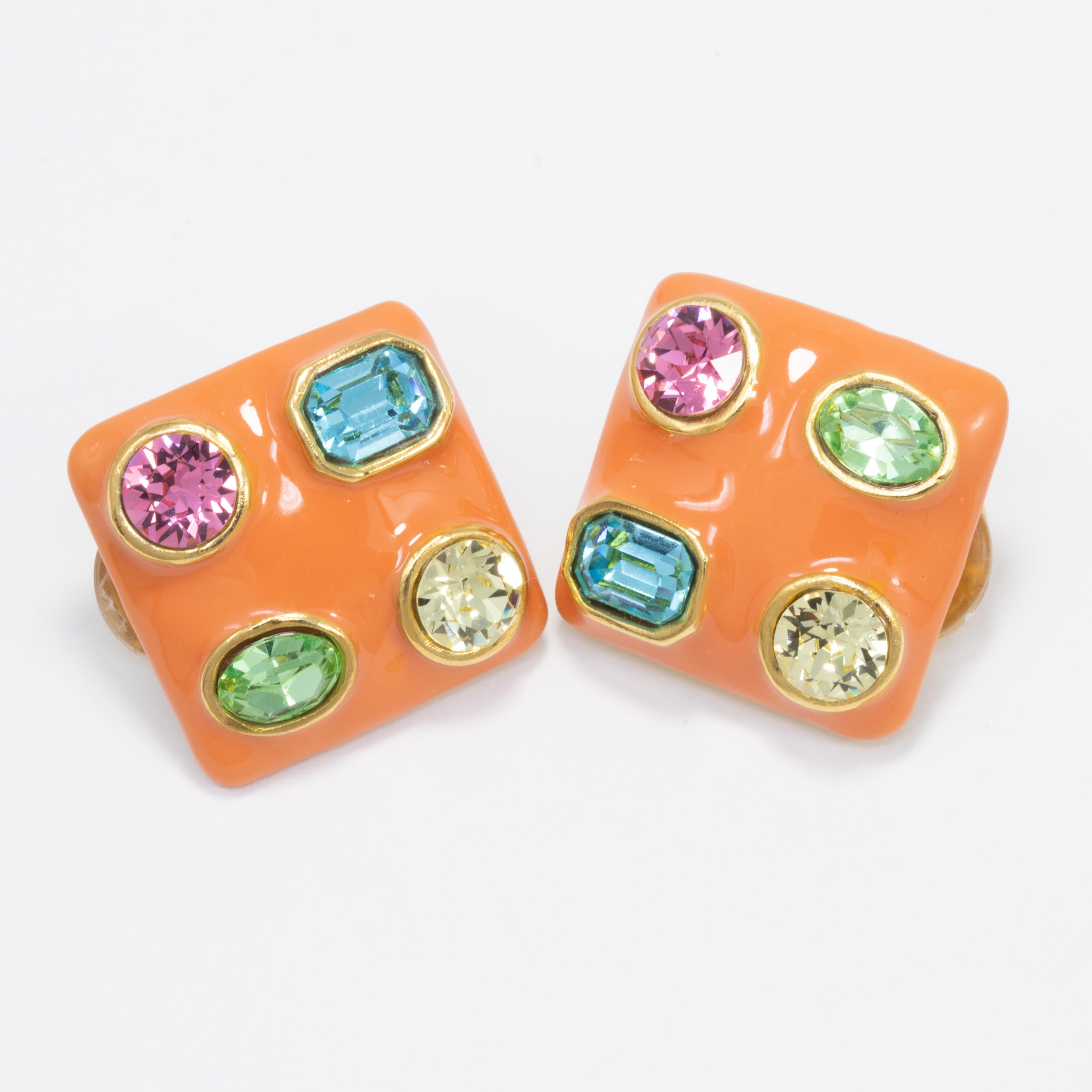 A pair of clip on earrings by Kenneth Jay Lane. Each gold-plated earring is painted in coral orange enamel, and decorated with colorful crystals.

Crystals: Aquamarine, peridot, rose, topaz

Tags, Marks, Hallmarks: KJL, Made in USA