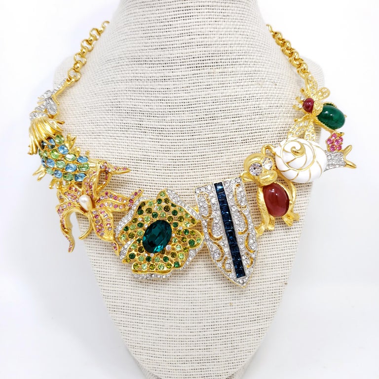 Kaleidoscope necklace by Kenneth Jay Lane. Signature KJL designs linked together to form a dazzling statement necklace! Colorful koi fish, flowers, jelly belly monkey, snail, fly, and art deco motifs.

Features faux pearls, painted enamel, cabochons