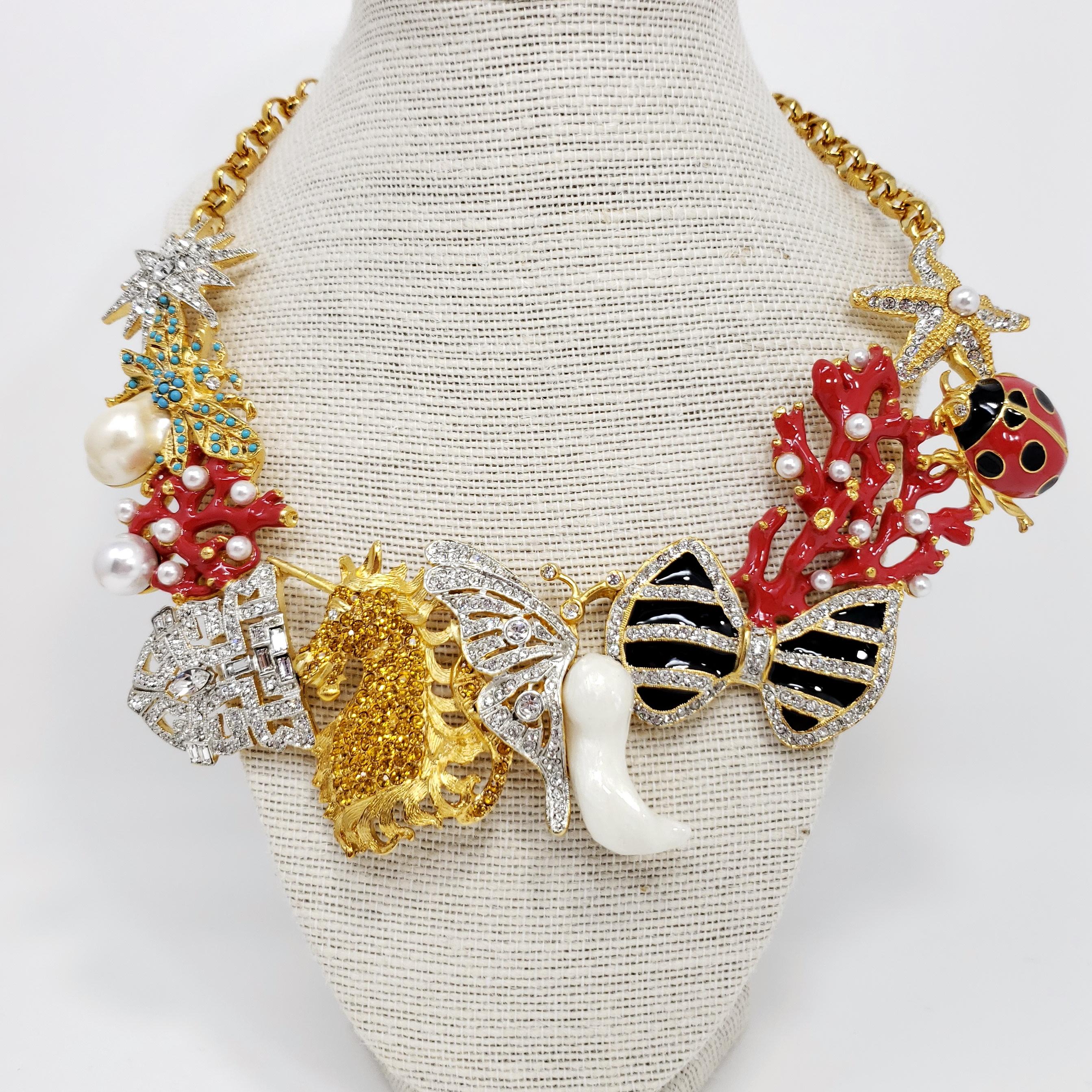 Kaleidoscope necklace by Kenneth Jay Lane. Signature KJL designs linked together to form a dazzling statement necklace!

Includes colorful star, fly, coral, art deco, unicorn, butterfly, bow, ladybug, and starfish motifs.

Features faux pearls,