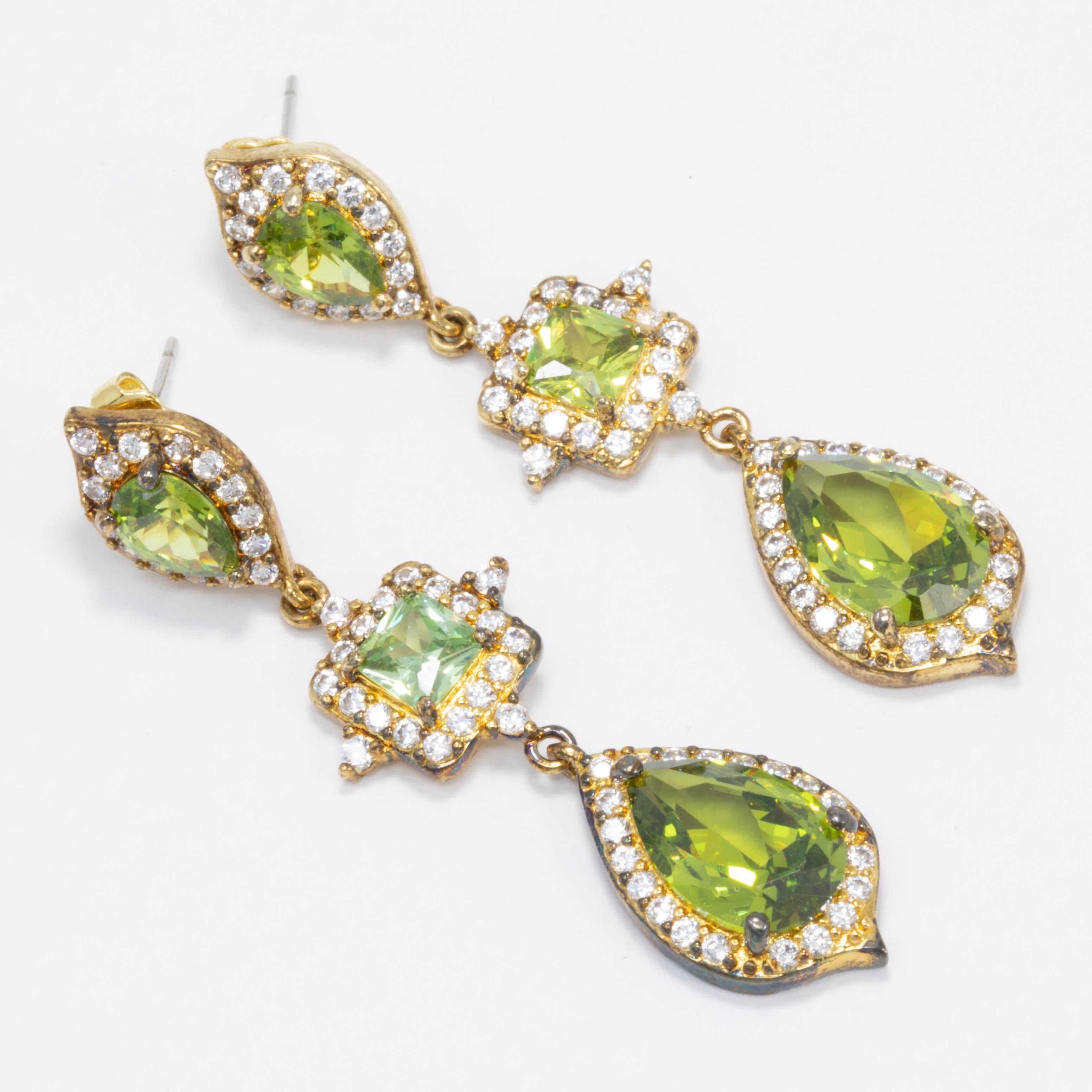 Add some sparkle to your outfit with these gold plated drop earrings by Kenneth Jay Lane.

Clear and green peridot cubic zirconia crystals. Post back.

Marks/Hallmarks: KJL

CZ by Kenneth Jay Lane line. Designed in New York. Made in China.