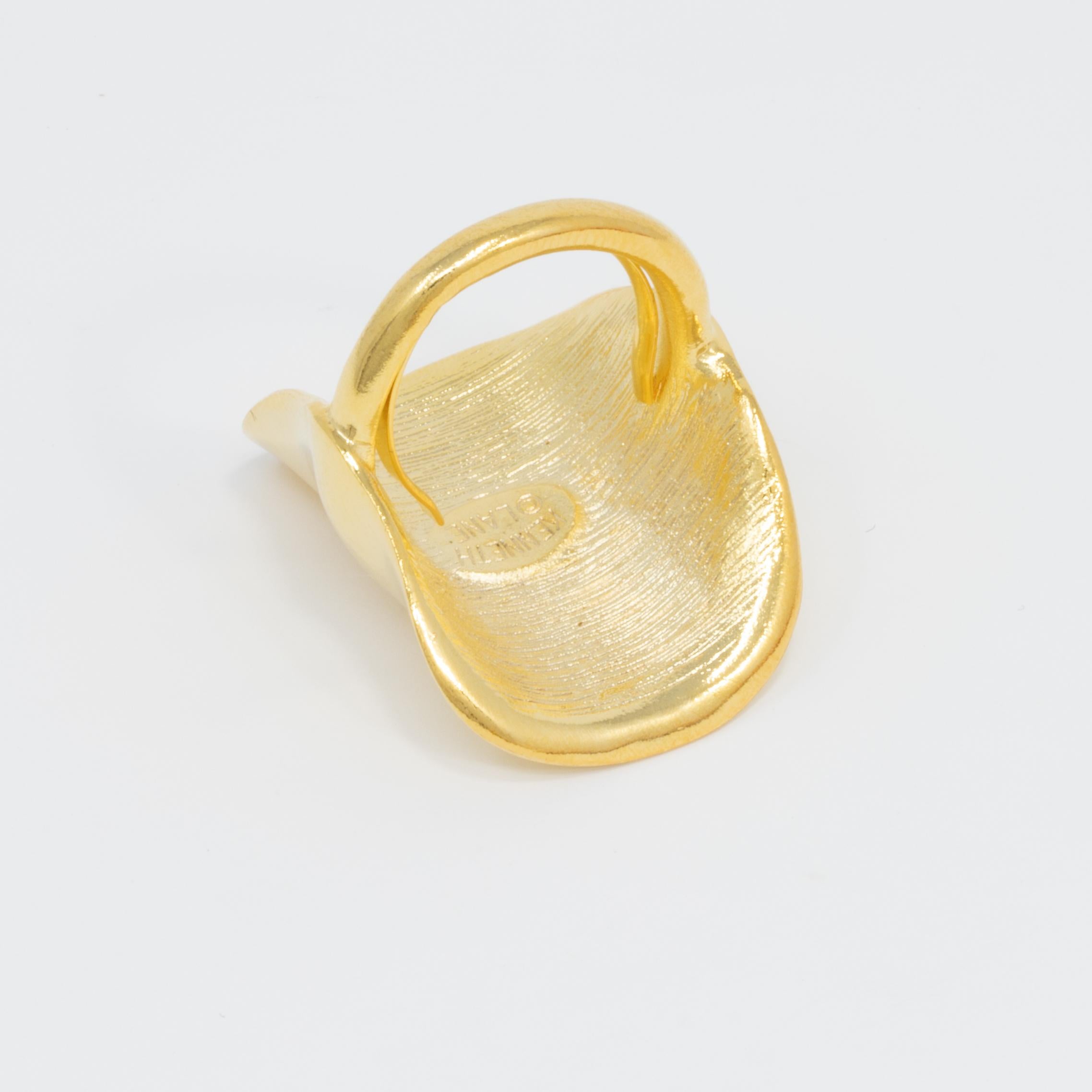 A flashy, polished-gold, statement ring. Add a perfect touch of golden glow with this ring from Kenneth Jay Lane!

Gold-plated.

Adjustable sizes 5 to 8.5 

Tags, Marks, Hallmarks: Kenneth Lane