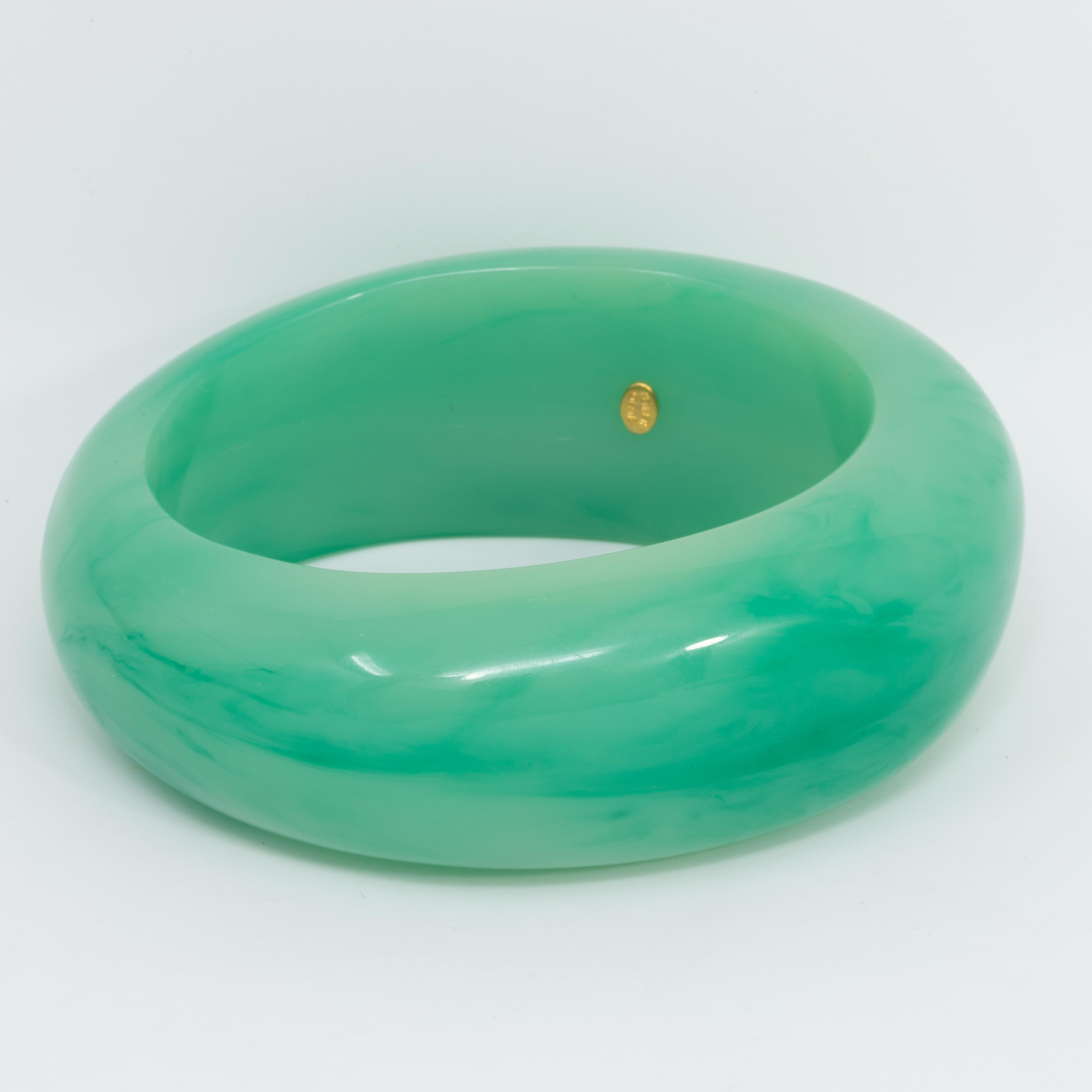 Art deco style asymmetrical style bangle bracelet by Kenneth Jay Lane in luxurious faux jade. 

Inner circumference: 7.75 inches
Inner diameter at widest part: 2.75 inches

Marks / hallmarks / etc: Kenneth Lane