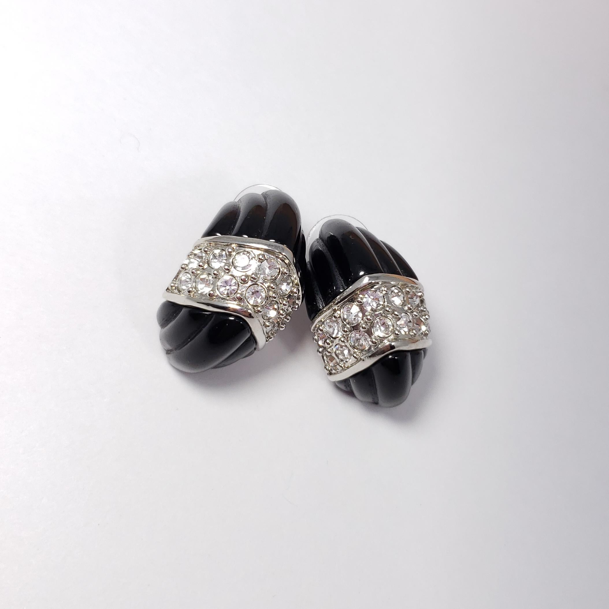 A pair of post-back earrings by Kenneth Jay Lane. Each carved black earrings is decorated with clear pave crystals set in a silvertone setting.

Hallmarks: KJL, China