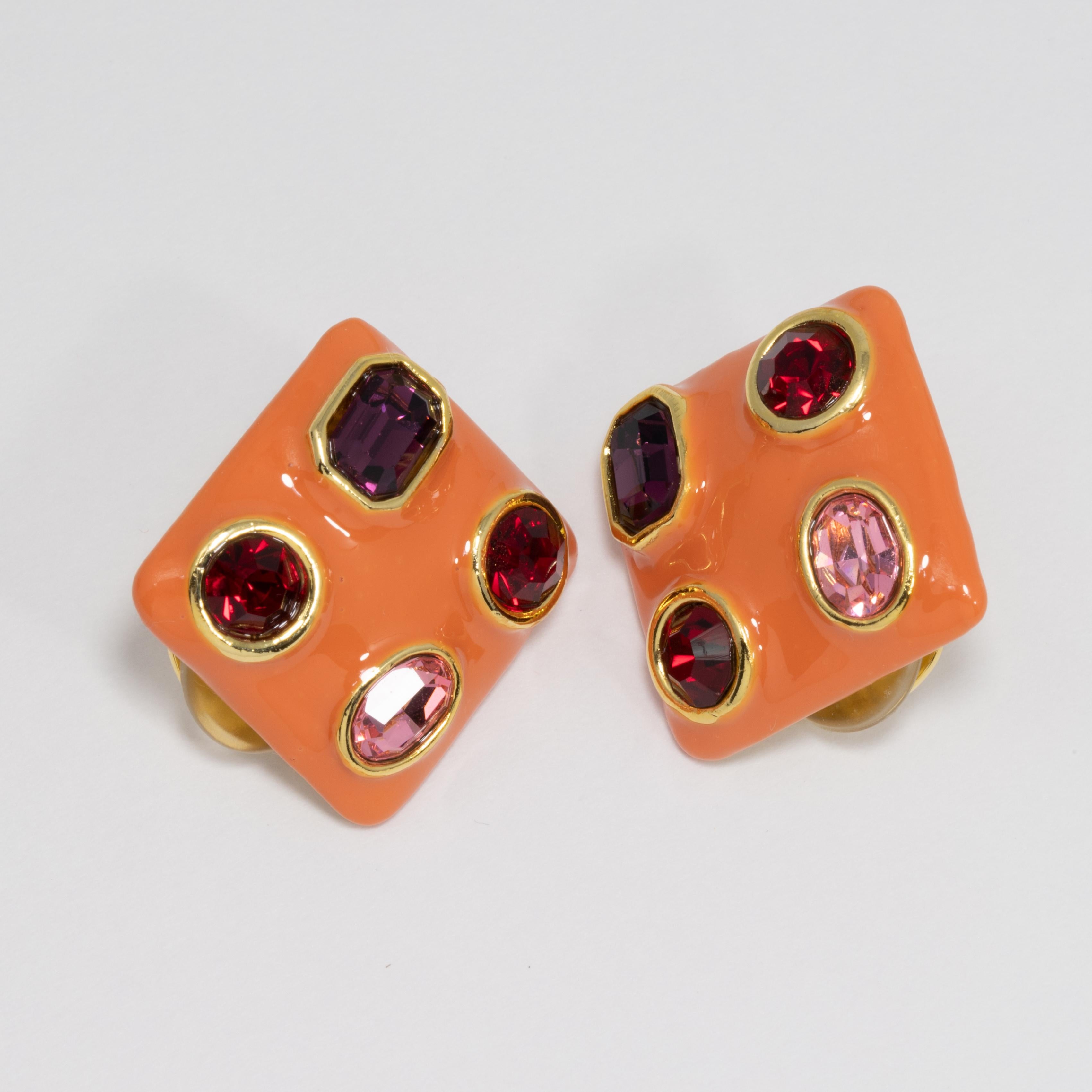 Stylish Kenneth Jay Lane earrings, featuring rose, amethyst, and ruby crystals bezel set ina orange enamel square clip on earrings.

Hallmarks: KJL, Made in USA