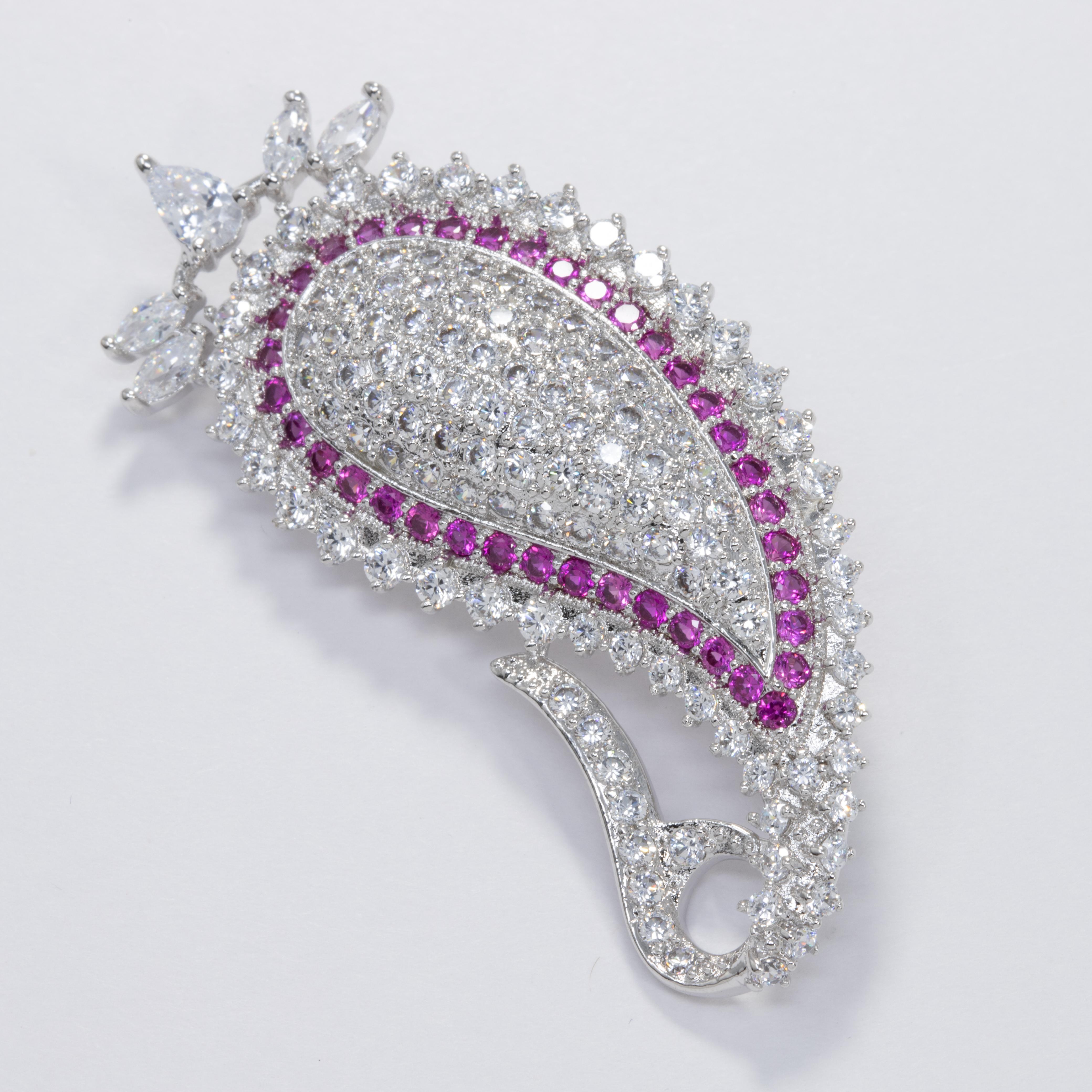 Sparkling brooch by Kenneth Jay Lane - a pave clear cubic zirconia crystal paisley motif accented with an amethyst crystal outline.

Hallmarks: KJLane