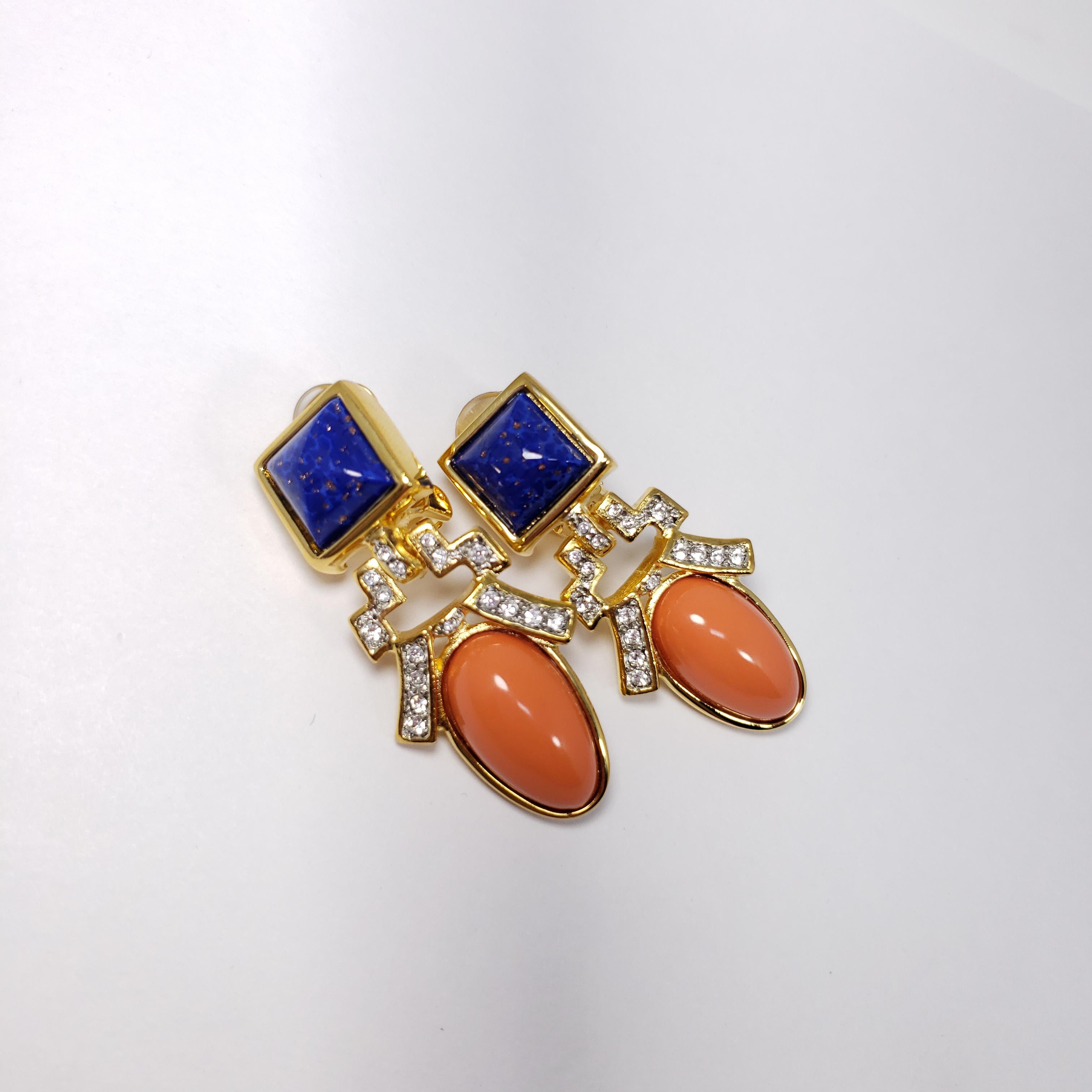 Stylish art deco-style earrings by Kenneth Jay Lane. Each earring features a faux lapis lazuli and coral cabochon, accented with crystals. All set in gold-plated metal.

Hallmarks: KJL, Made in USA