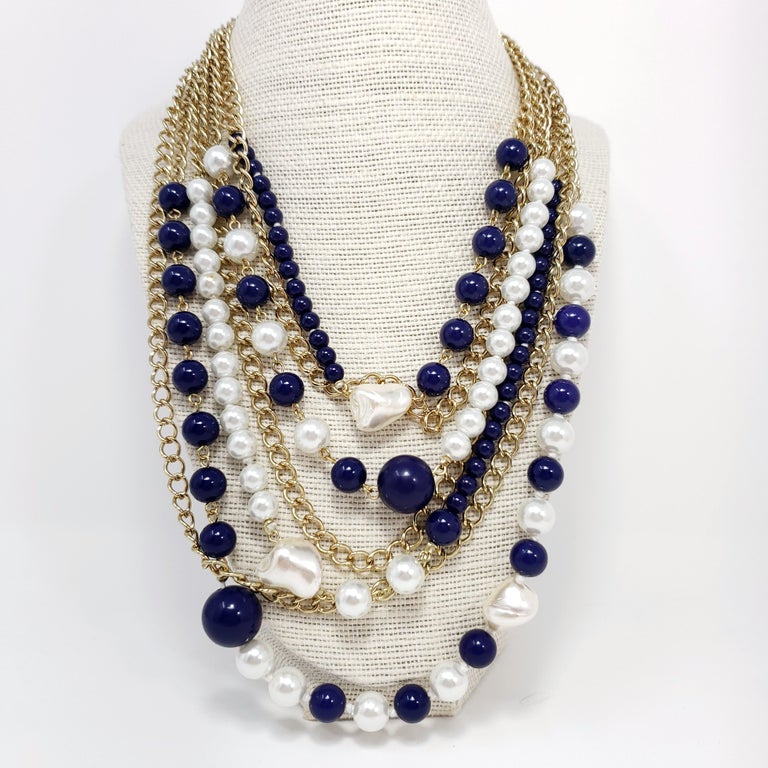 An extravagant collar necklace from Kenneth Jay Lane! Features strands of faux pearl, mother of pearl, and lapis lazuli beads on gold link chains. 

Hallmarks: Kenneth Lane

Length of shortest strand: 17.5 in / 45 cm