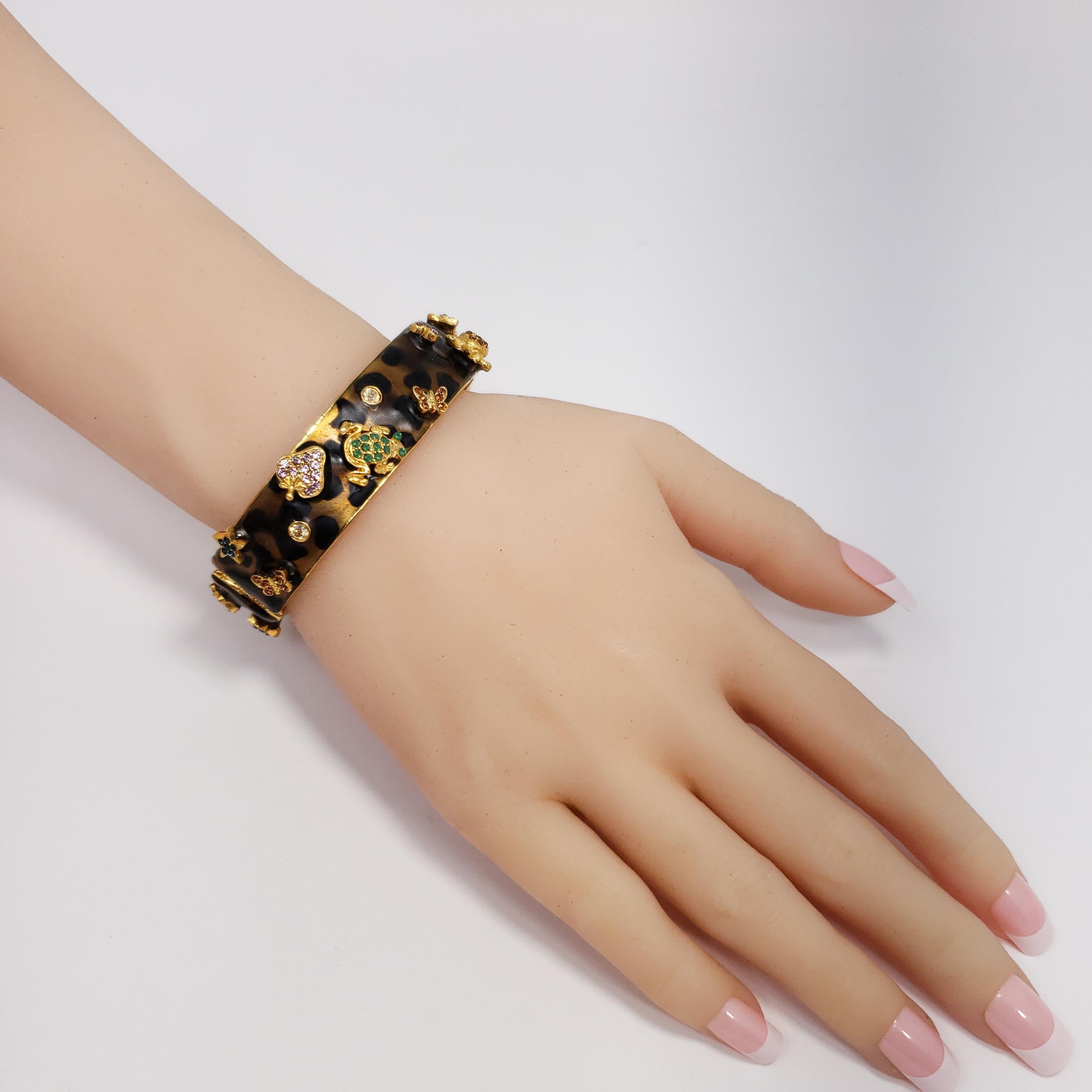 A bracelet by Kenneth Jay Lane in an exotic leopard pattern. Features raised gold-plated motifs accented with colorful crystals.

Height: 1.6 cm / 0.6 in
Diameter at widest part: 5.56 cm / 2.19 in
Inner circumference: 16.5 cm / 6.5 in 

Hallmarks: