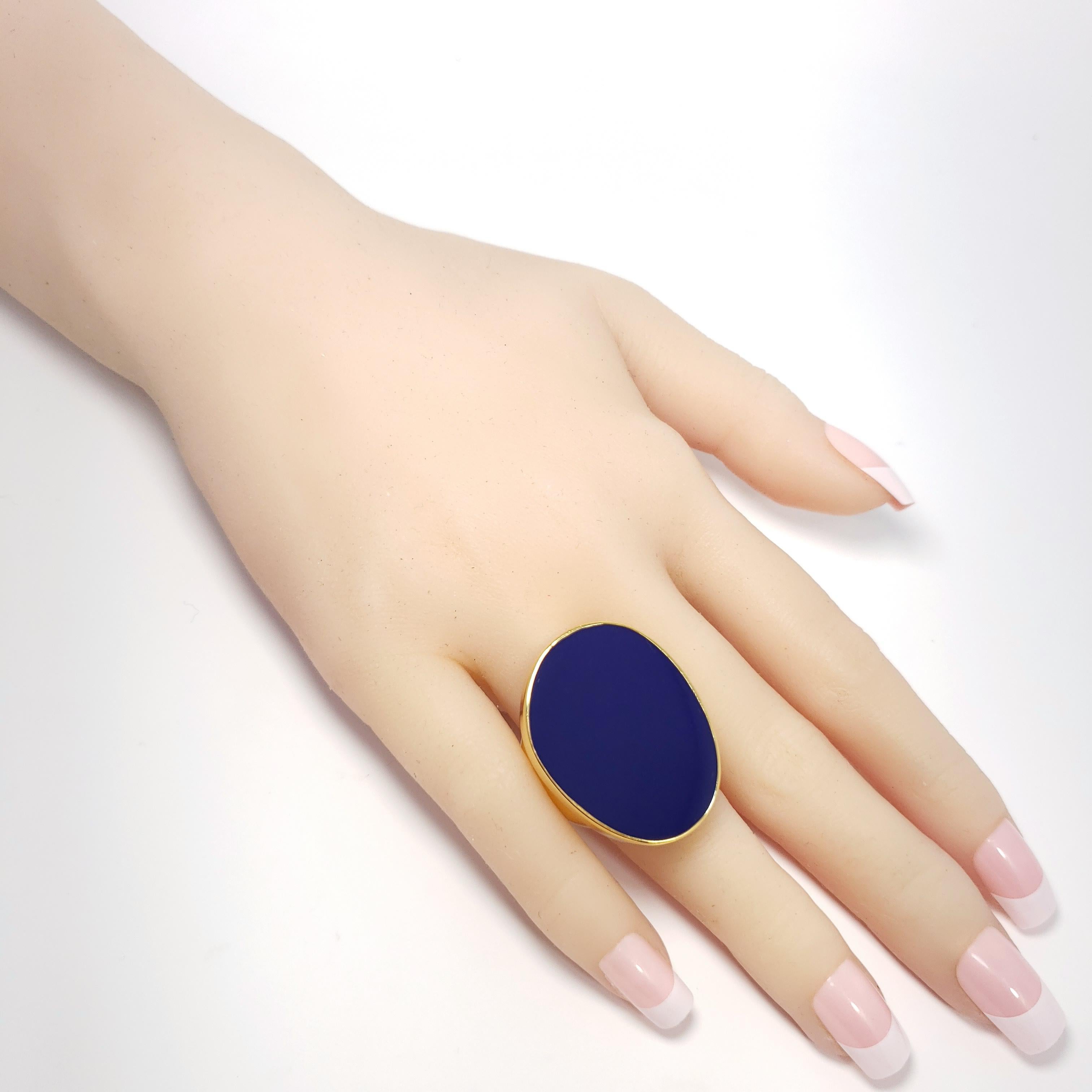 A stylish cocktail ring with an oval, deep-blue, enamel, center. Bezel set in a gold-plated setting.

Adjustable sizes from 5 to 8.5

Hallmarks: Kenneth Lane