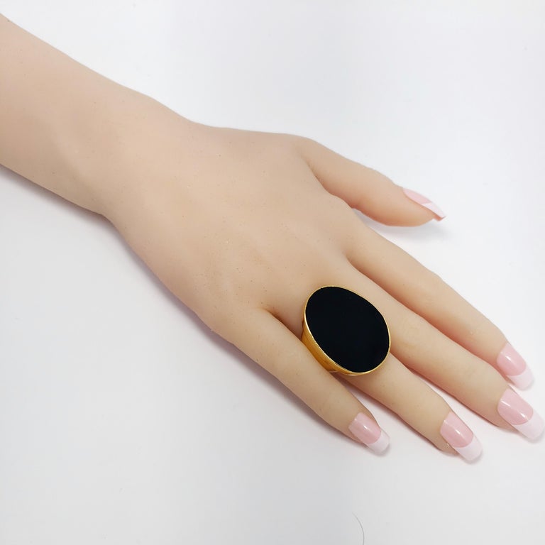 A stylish cocktail ring with an oval, midnight-black, enamel center. Bezel set in a gold-plated setting.

Adjustable sizes from 5 to 8.5

Hallmarks: Kenneth Lane
