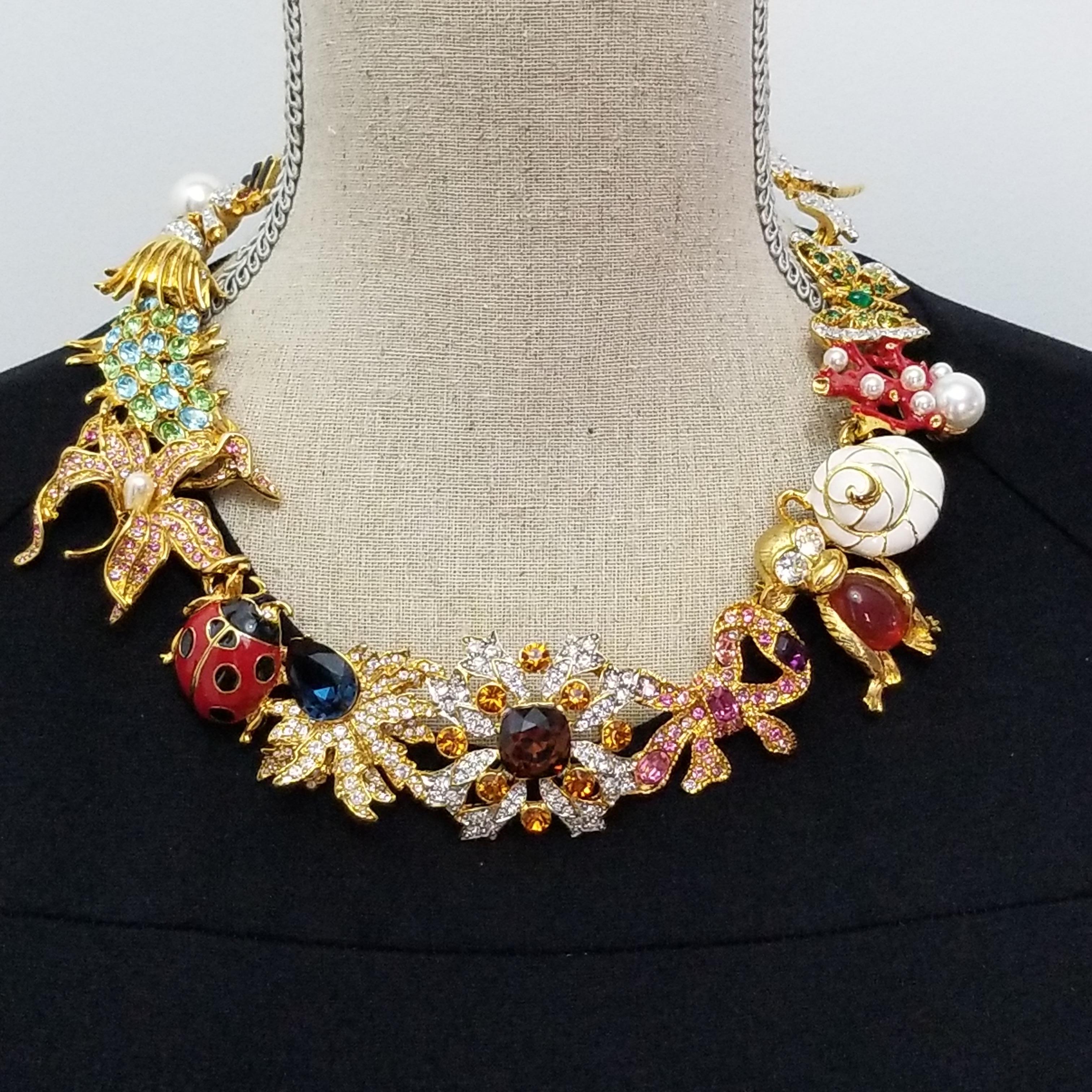 Kaleidoscope necklace by Kenneth Jay Lane. Famous whimsical KJL designs linked together to form a dazzling statement necklace! Colorful dragonfly, butterfly, coral, seashell, monkey, bow, flower, ladybug, and spider motifs. The motifs are linked