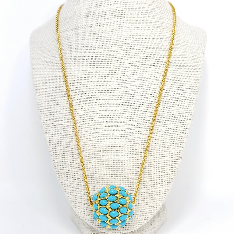 A pave turquoise-colored cabochon ball pendant hangs on a fine gold chain. Pendant necklace by Kenneth Jay Lane.

Gold plated.

Tags, Marks, Hallmarks: Made in USA

Length: 21.5 to 23.5 inches