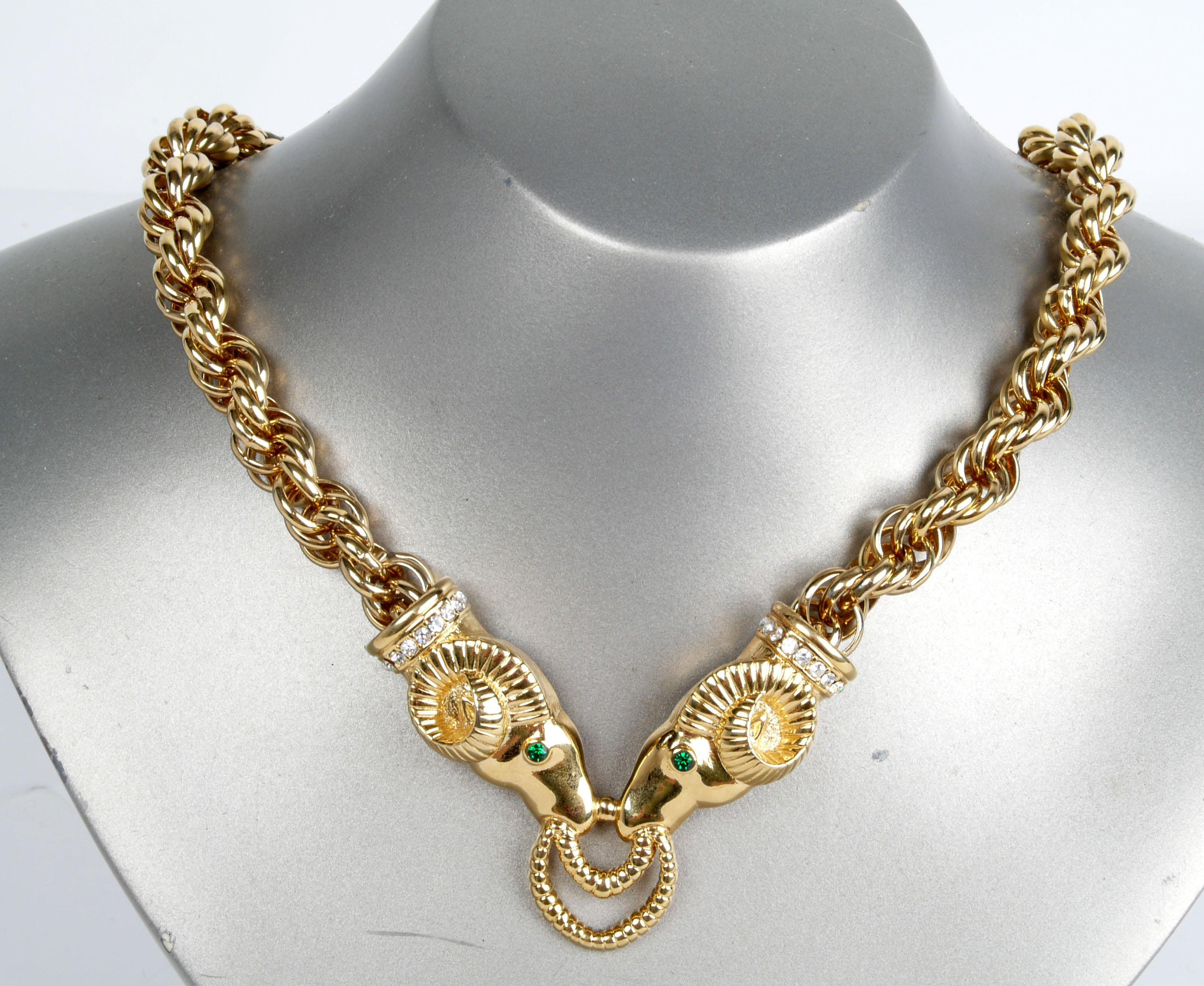 Kenneth Jay Lane gold tone ram's head necklace and clip back earrings adorned with rhinestones. 
Maker's mark on all pieces, 