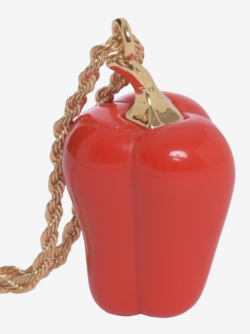 Kenneth Jay Lane Red Bell Pepper Necklace is made by red resin bell pepper decorated with Hamilton gold-plated American pewter casting. 
Lane started designing jewelry and launched his business in 1963 while producing bejeweled footwear for Dior and
