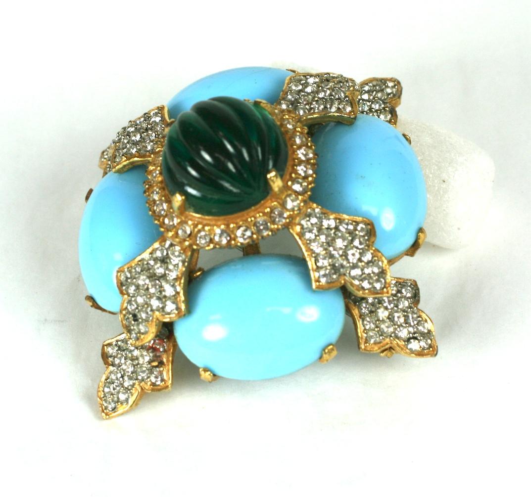 Kenneth Jay Lane dimensional oval turquoise cabochon and melon cut emerald crest brooch with fine crystal pave set in gilt metal. 
Excellent Condition. 1960's USA. 
Length 2.75