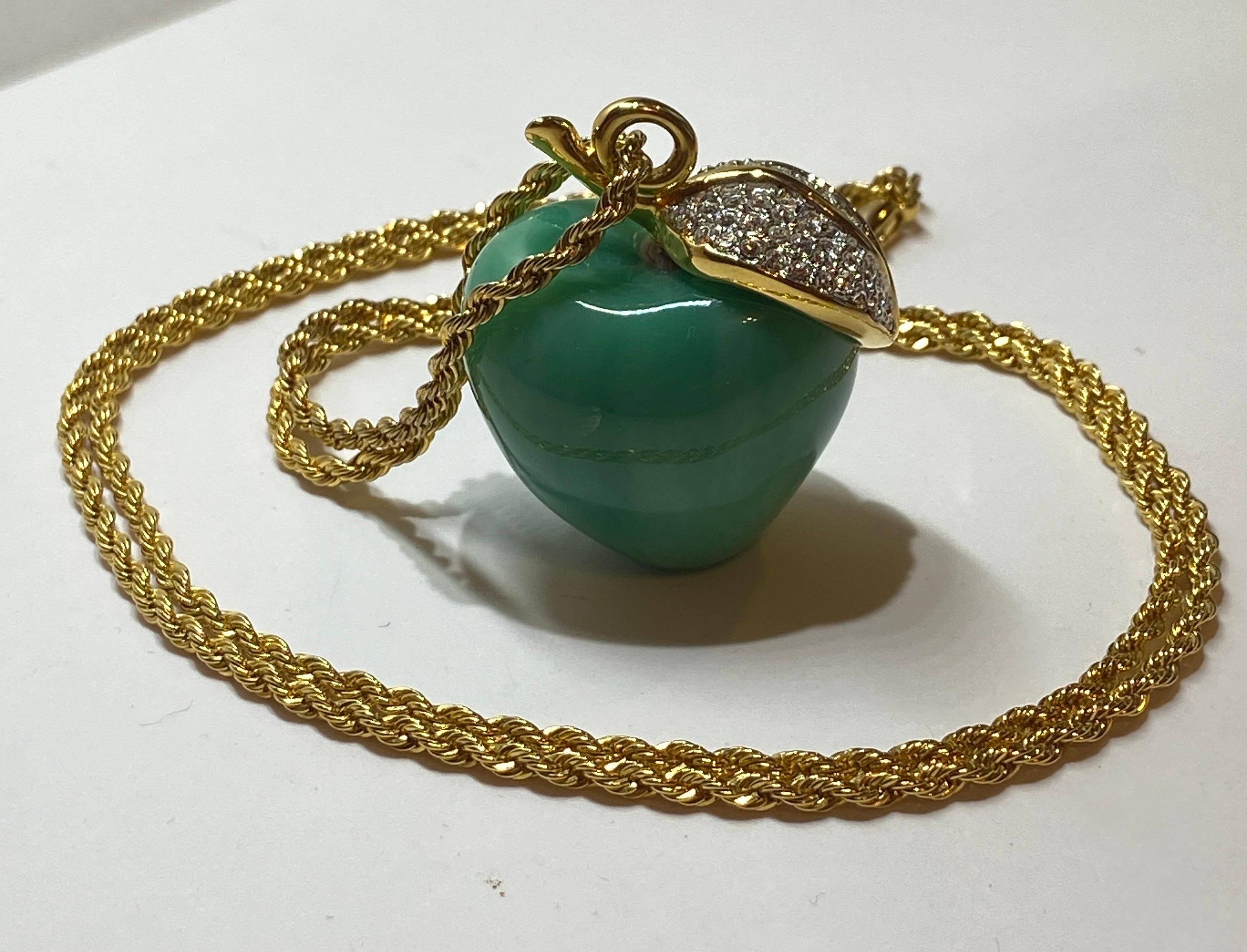 Kenneth Jay Lane's wonderfully whimsical large jade-green lucite apple is studded with rhinestones throughout. Accented with gilded gold hardware surrounding the rhinestone leaf, the matching gilded gold hardware necklace is styled in a 