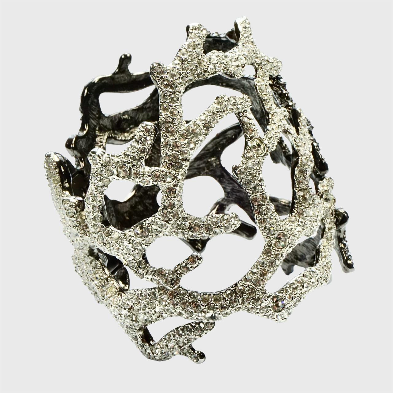 Favoloso bracciale Kenneth Lane in metallo grigio scuro con design a corallo e cristalli trasparenti e grigio scuro a contrasto.

Misure del diametro interno: lunghezza 5,8 cm / 2,28 pollici e larghezza 4,8 cm / 1,8 pollici. La larghezza è di circa