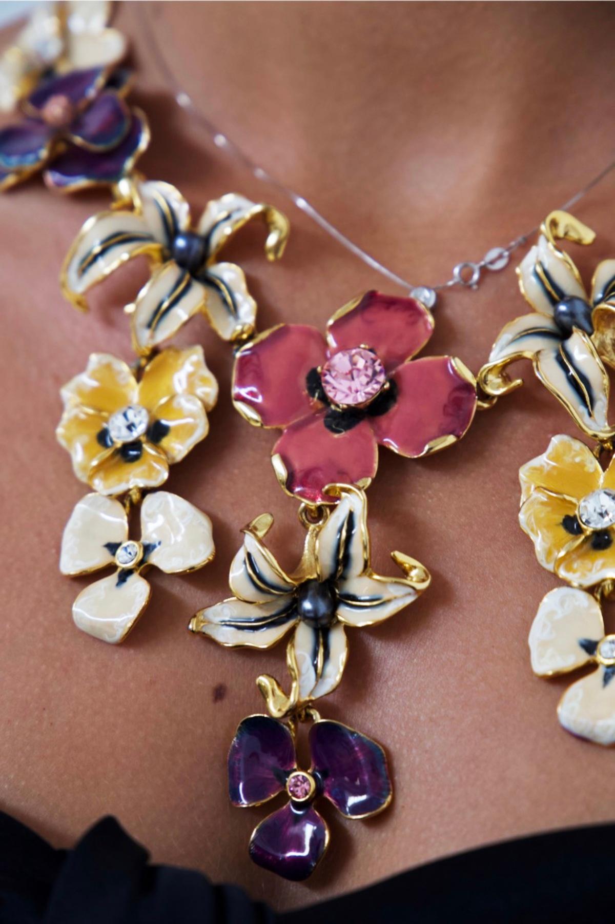Joli collier floral conçu par Kenneth Lane dans les années 1990, belle fabrication française.
Le collier s'étend sur 10 rangées horizontales de petites fleurs colorées dans des tons de rose, violet, blanc et jaune.
Le collier se fixe derrière le cou