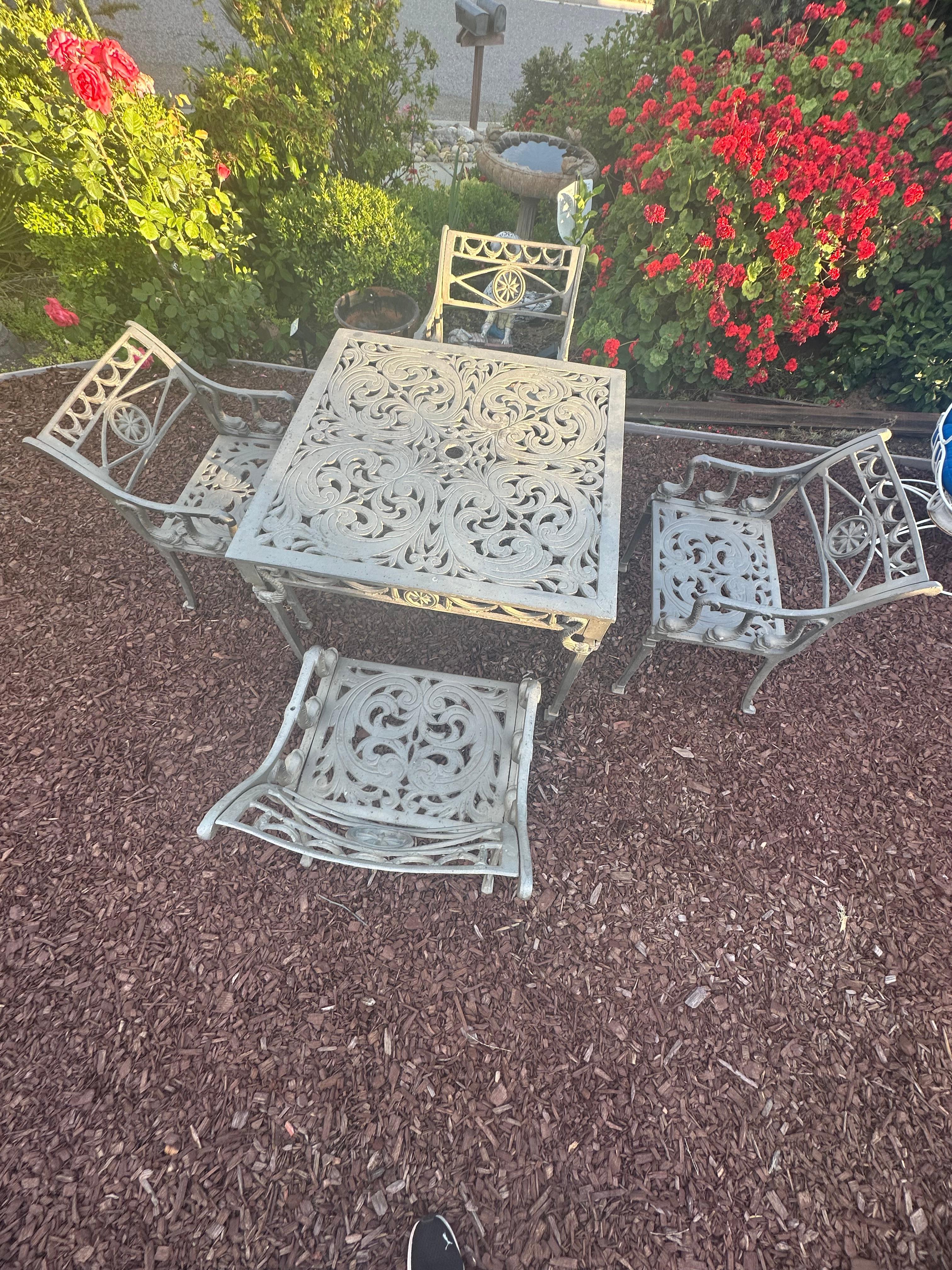 Kenneth Lynch & Sons Filigree Design
Star & Dolphin pattern Dining set
Four arm chairs and table with opening for umbrella.  
This set will last you another 70 years 
Circa 1950's
OF THE PERIOD: Mid-Century Modern
MATERIALS: Cast aluminum
CONDITION: