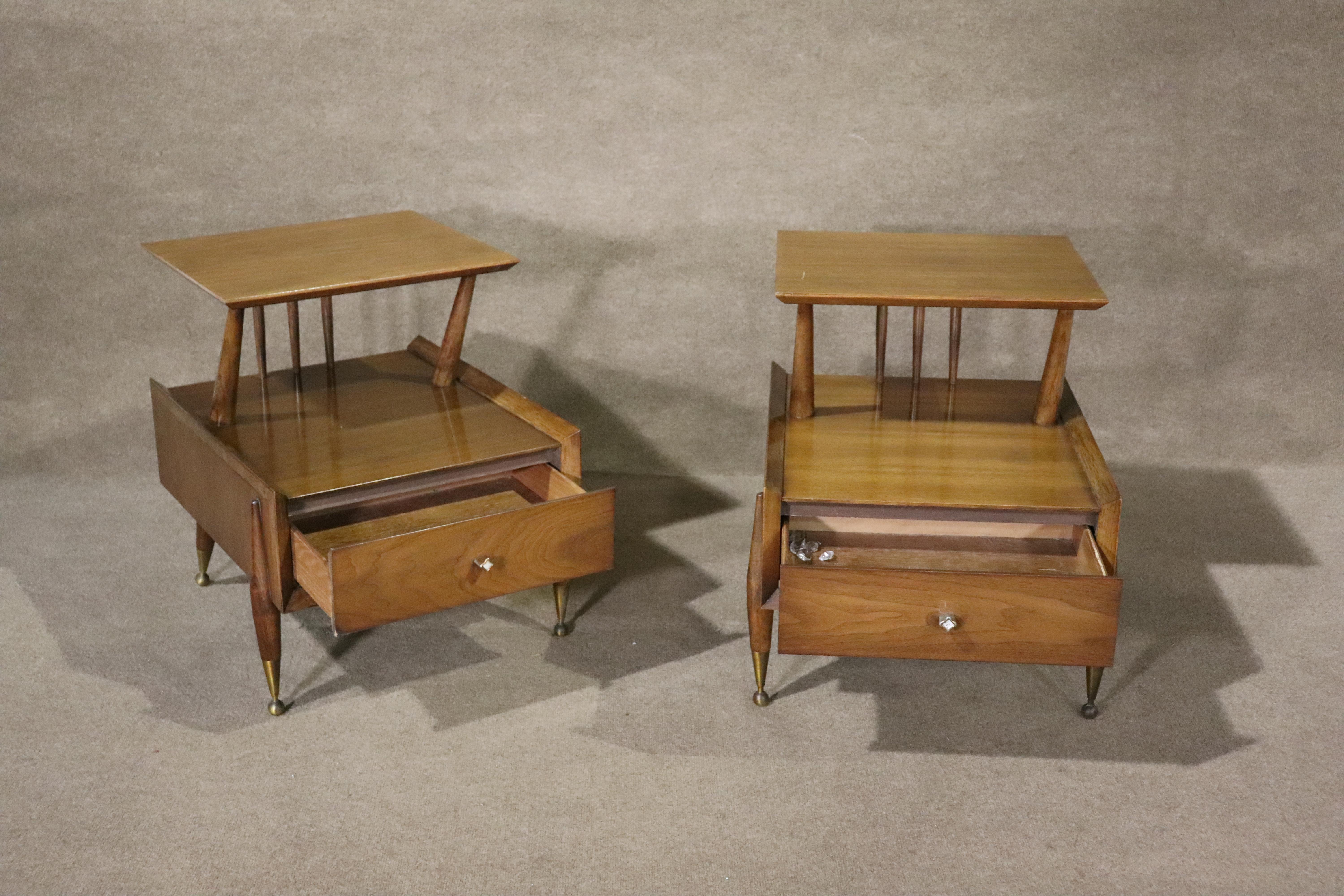 Paire de tables d'appoint à deux niveaux de style moderne du milieu du siècle dernier par Kent Coffey. Grain de noyer chaud et quincaillerie en laiton.
Veuillez confirmer le lieu NY ou NJ