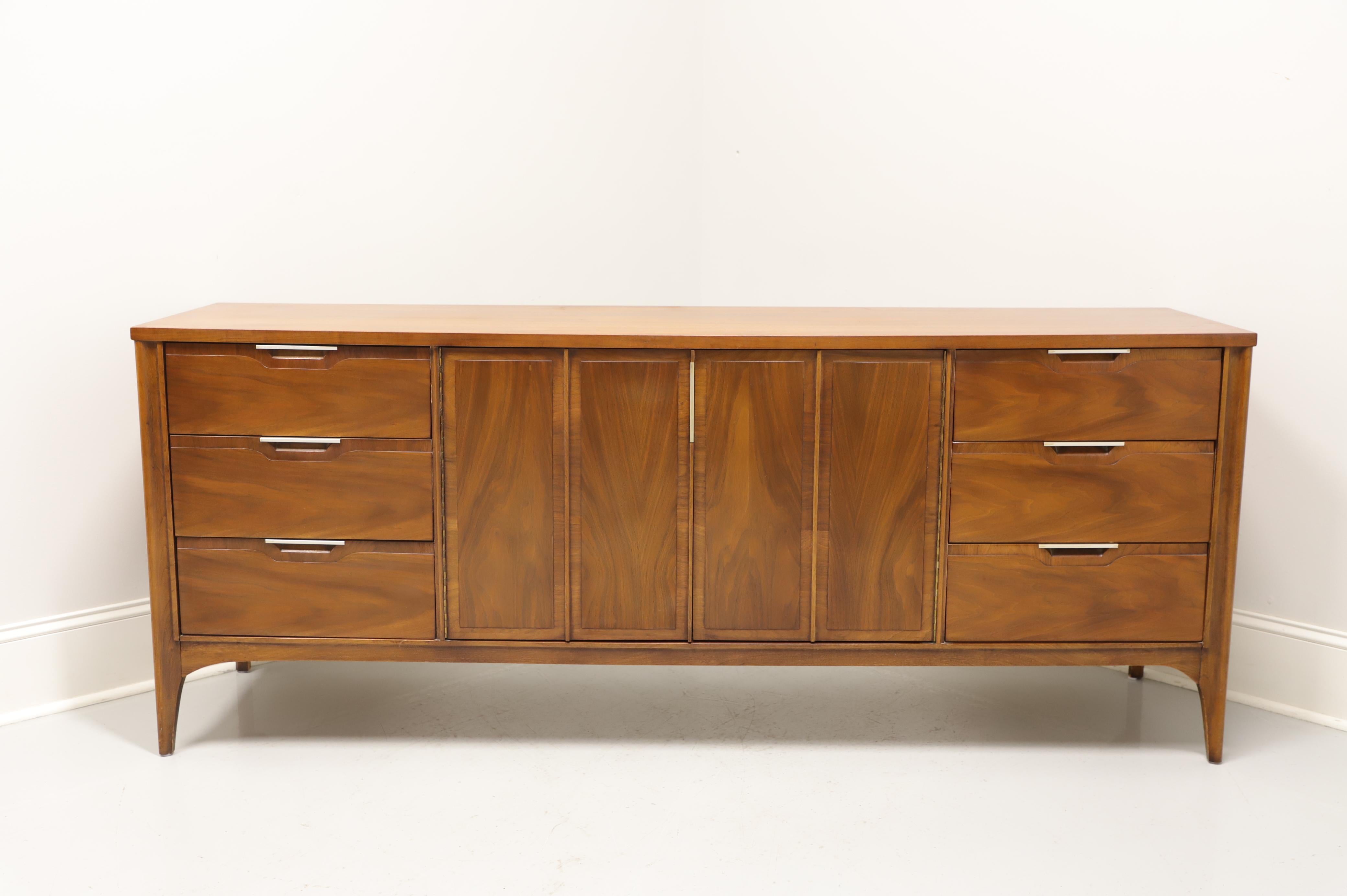 A Mid-Century Modern dresser by Kent Coffey, of Lenoir, North Carolina, USA, from their Impact line. Mahogany with brass hardware. Features right and left side with three drawers of dovetail construction. Center with dual doors revealing three more
