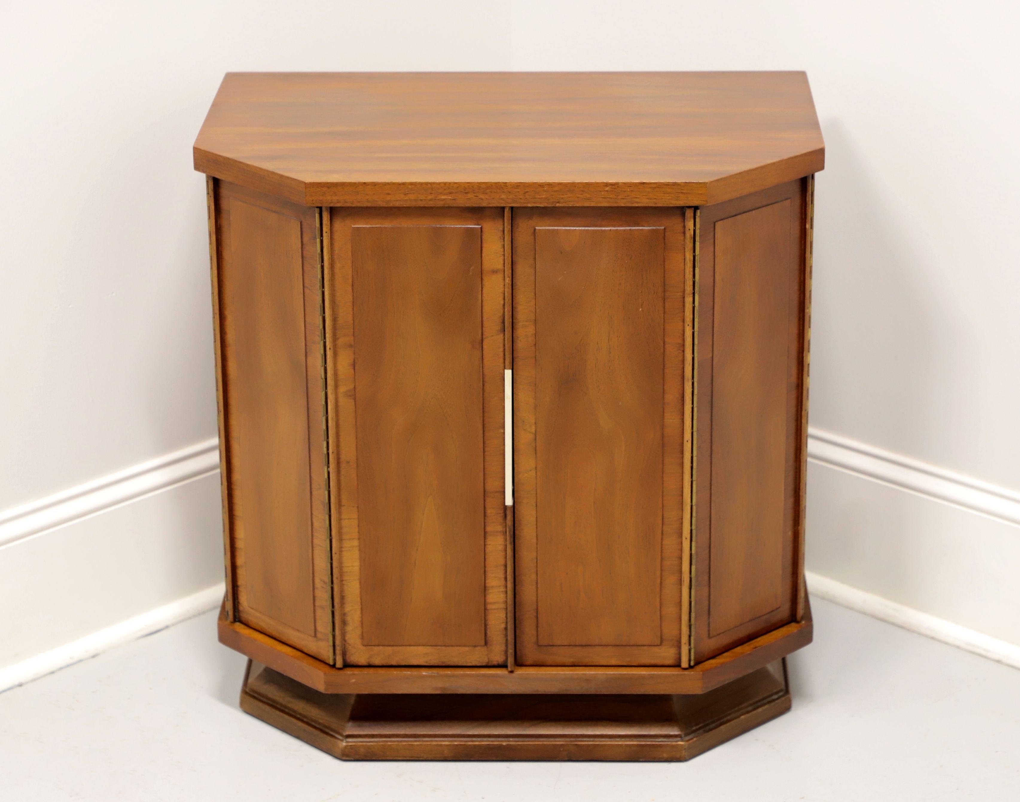 A Mid Century Modern nightstand by Kent Coffey, of Lenoir, North Carolina, USA, from their Impact line. Walnut and elm, brass hardware, banded door fronts and sides. Features dual bifold doors revealing one dovetail drawer and storage area with one