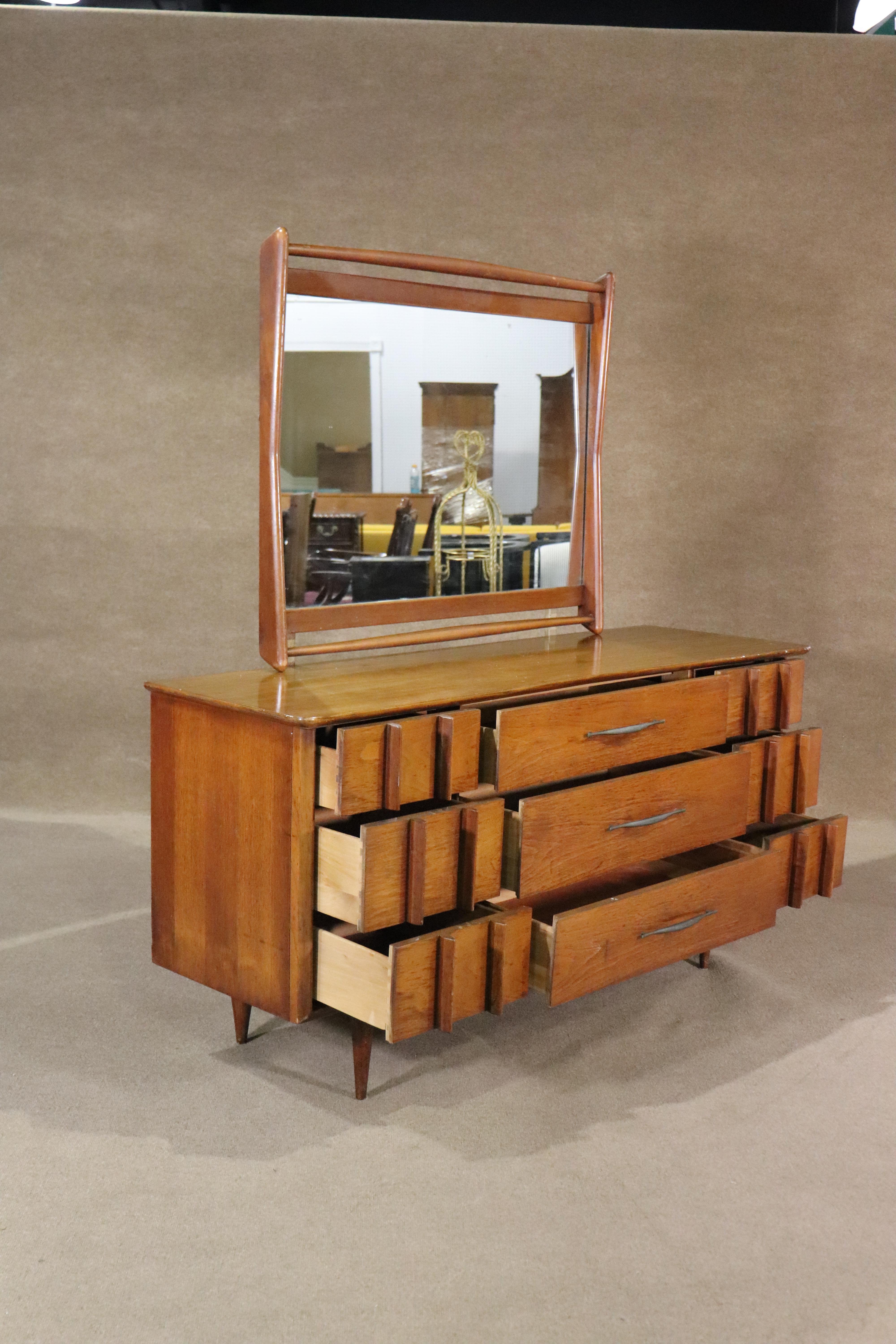Vintage modern American made dresser with mirror. Made by Kent Coffey for their 'Foreteller' collection. Nine drawers with sculpted legs and runner.
Mirror: 35h, 41.5w
Please confirm location NY of NJ.