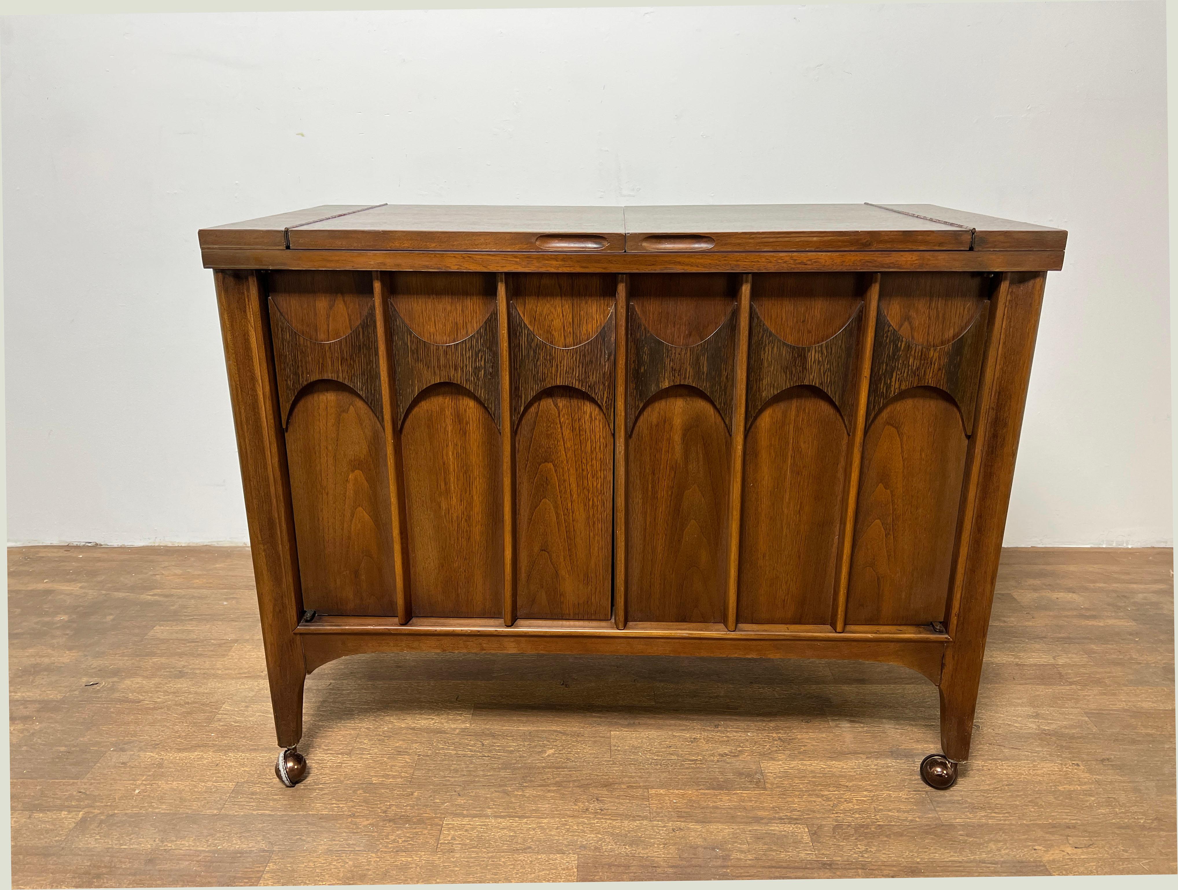 Mid-Century Modern bar with expandable flip-top in black melamine, perfect for serving drinks. From the Perspecta line by Kent Coffey Furniture.

With top fully open, this measures 62.25