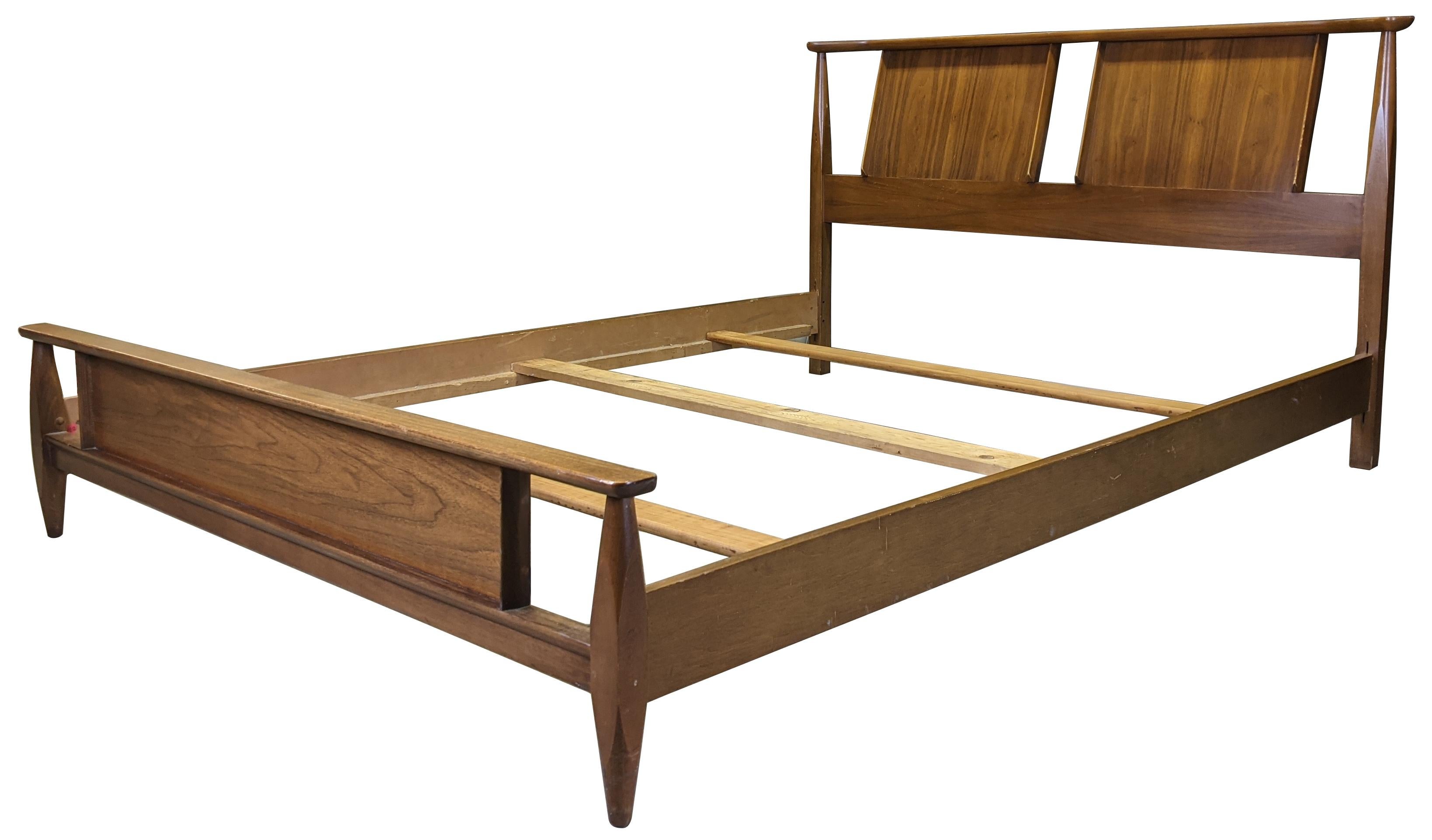 Vintage sculptural shaped full size bed by Kent Coffee. Made from continental walnut with tapered legs, circa 1960s. #6900.

Measures: Rail height 9
