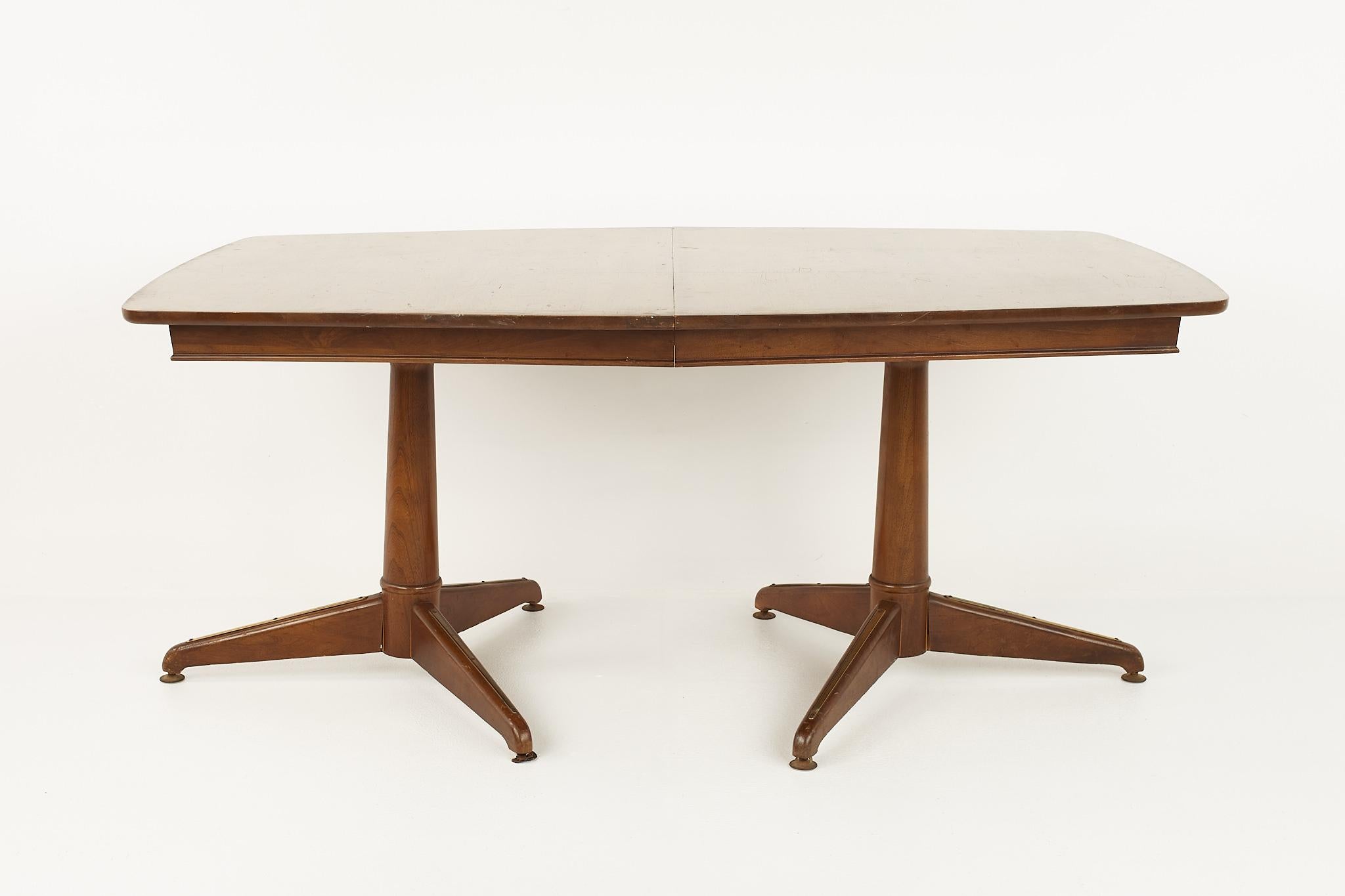 Kent Coffey mid century pedestal base 10 seat walnut dining table

The table measures: 63.75 wide x 42 deep x 27.5 inches high; each leaf is 12 inches wide, making a maximum table width of 99.75 inches when all three leaves are used 

All pieces