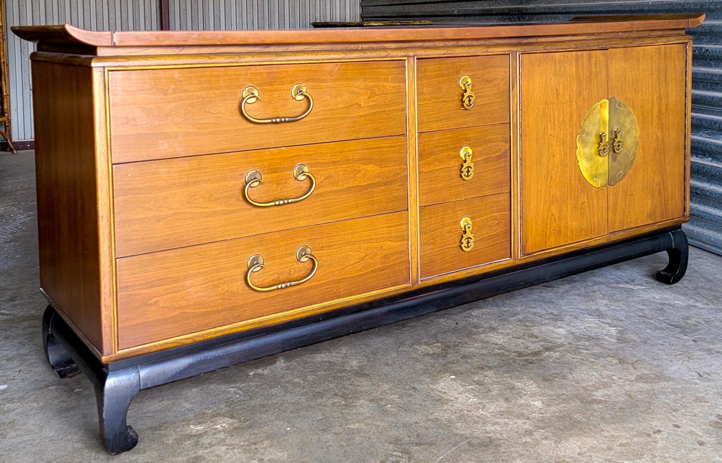 A versatile piece! From media storage to dining to bedroom, this Kent Coffey credenza is a winner. It is part of the Amerasia line that he designed in the 1970s. It is walnut with an ebonized Ming form base. The interior has drawers with dovetail