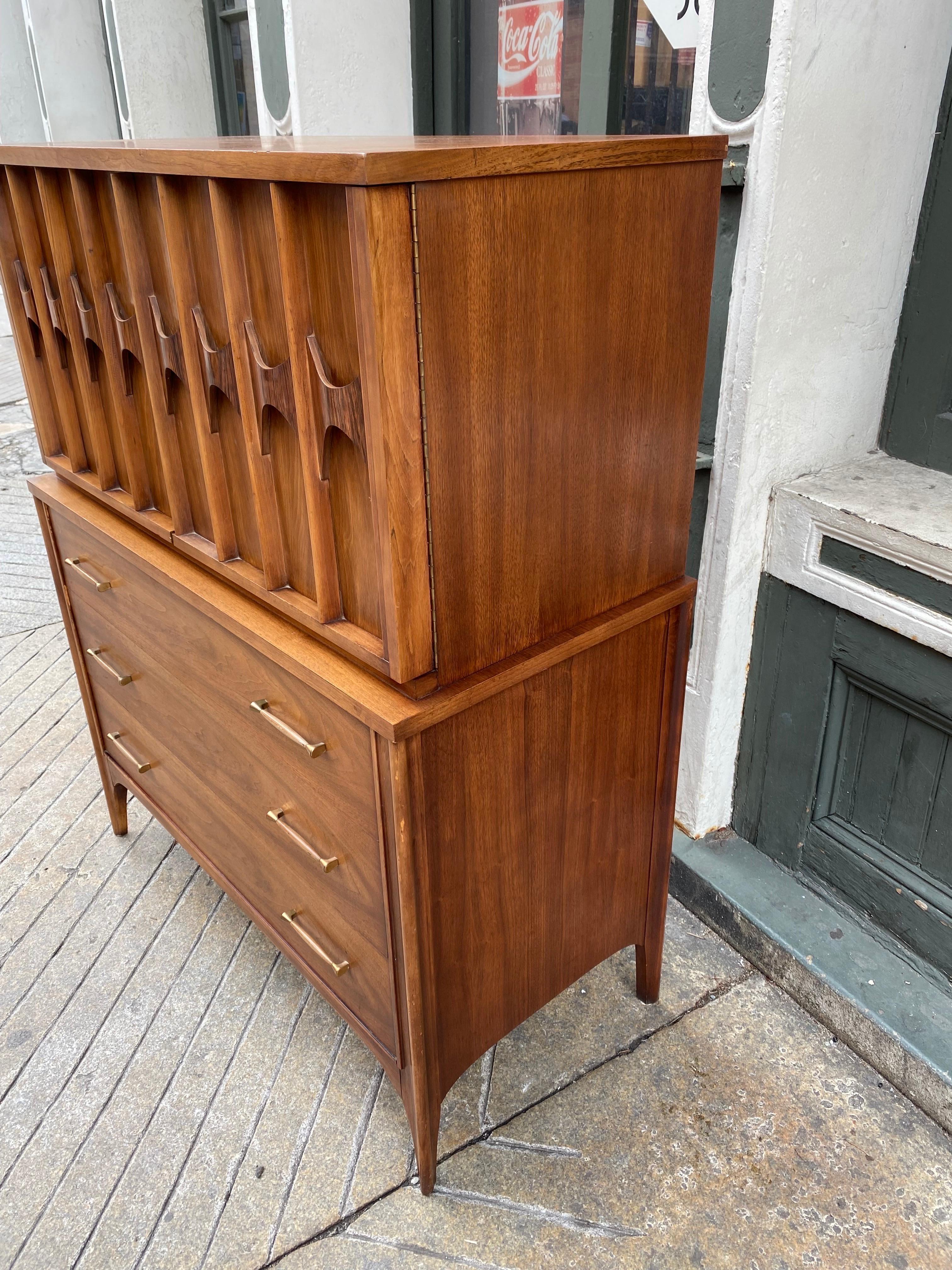 Kent Coffey armoire/ highboy. Tons of storage in this dresser! 3 Pull out drawers to bottom with 2 doors that swing open to reveal shelf area on the left and 2 pull out drawers on the right. Cabinet is accented with Rosewood that acts as the handles