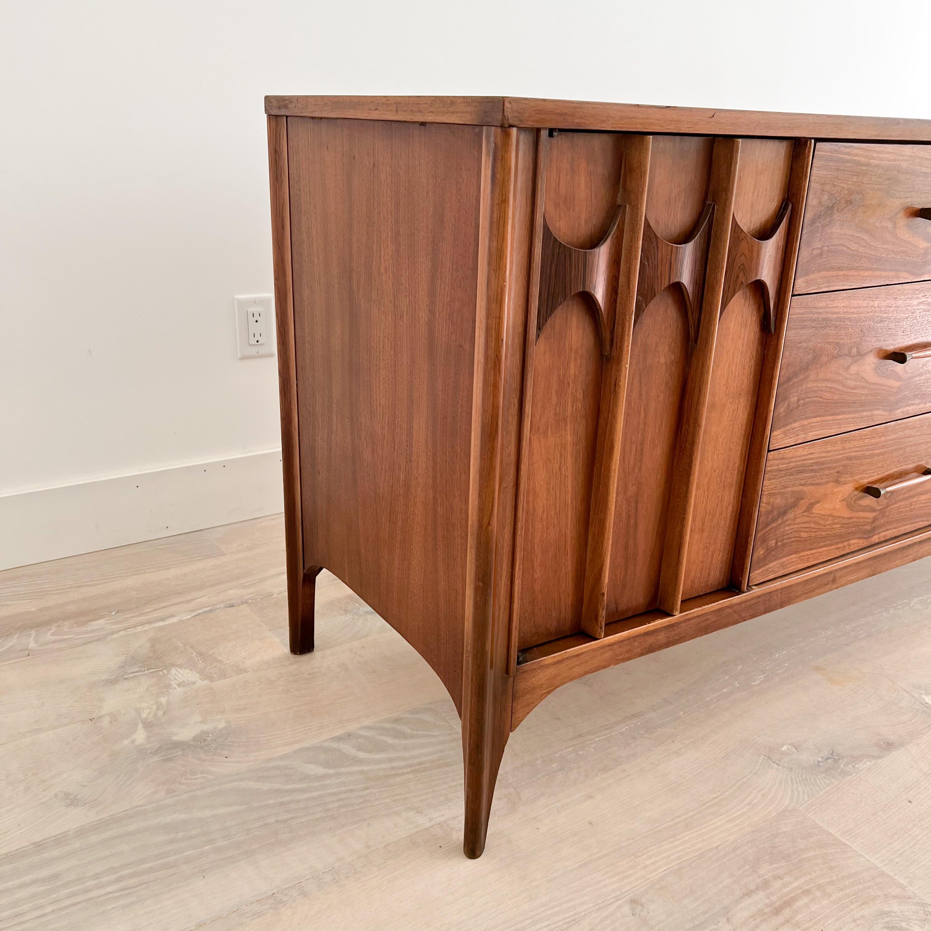 Mid-Century Modern walnut sculpted front 12 drawer dresser with rosewood accents by the Kent Coffey Persepcta line. Featuring six center drawers, two doors on each end that open up to three hidden drawers.