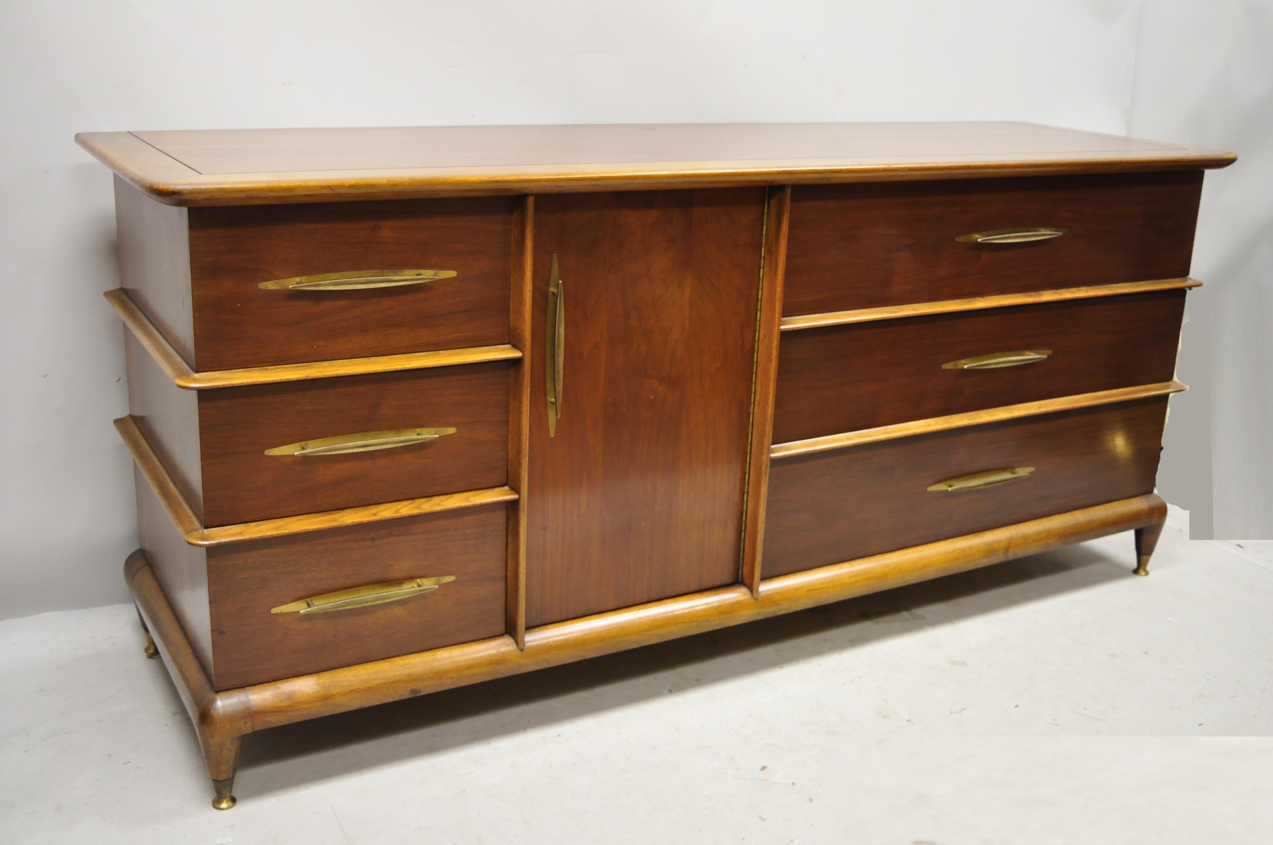 Kent Coffey The Appointment Mid-Century Modern sculpted walnut credenza cabinet long dresser. Item features brass capped feet, sculpted wood frame and trim, solid wood construction, beautiful wood grain, 1 swing door, original stamp, 9 dovetailed