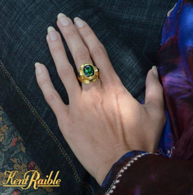 Kent Raible has out done himself in this gorgeous and bold bespoke cocktail ring. Beautiful flowing lines and the finest museum quality granulation out there. This miniature work of art features a deep Green Tourmaline and Blue Sapphire cabochons.
