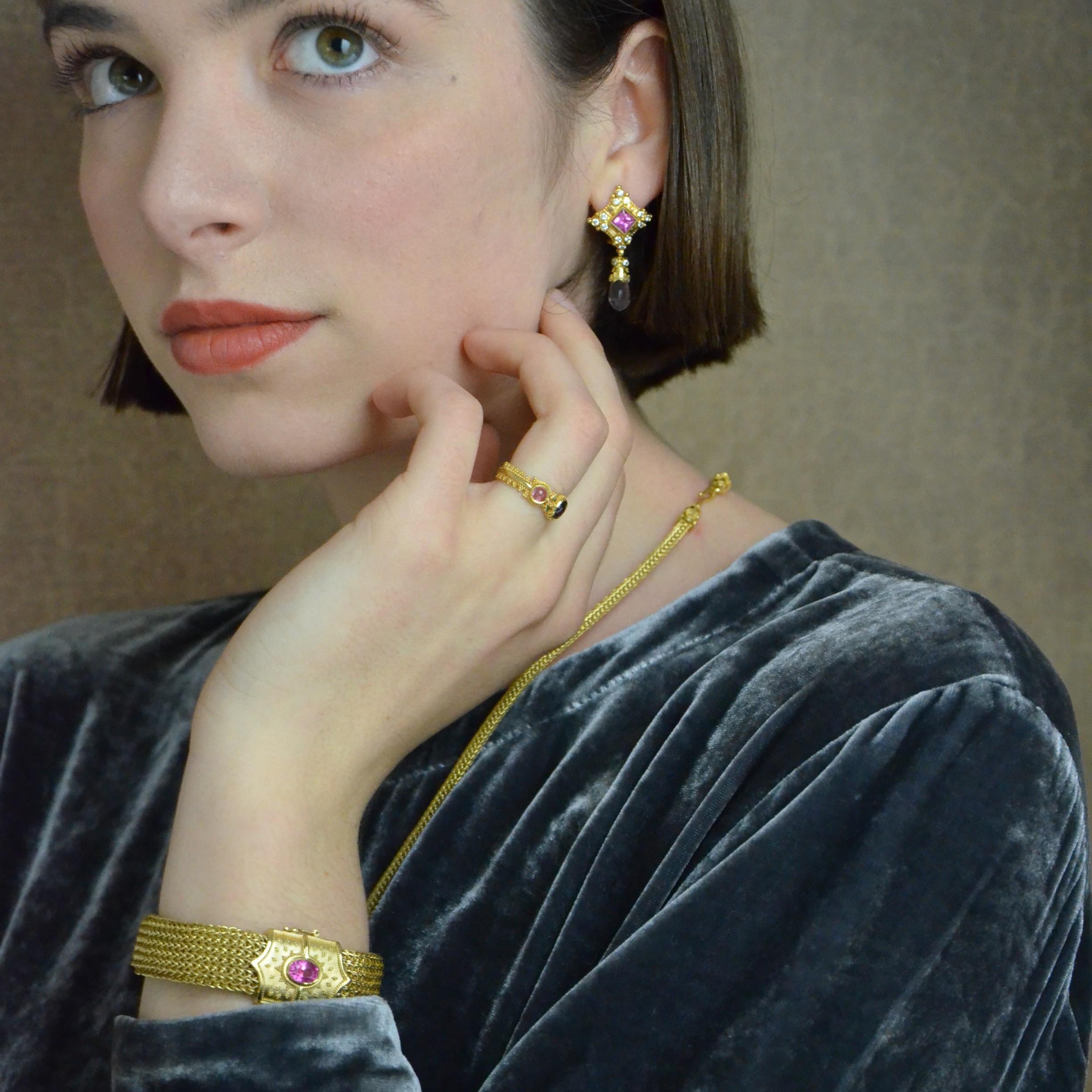 Timeless elegance is yours in Kent Raible's hand woven chain bracelet featuring a lovely bright Pink Sapphire. The bracelet opens by pressing on the Sapphire to release the clasp. Want to dress it down and just wear an all gold bracelet? Wear it