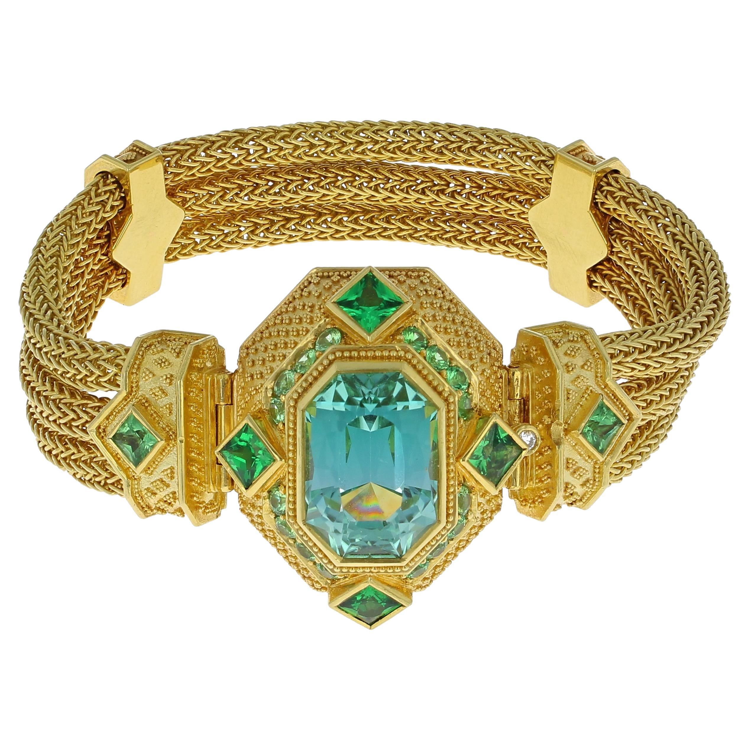 A stunning masterpiece from Kent Raible! 

Tourmaline (cut by Stephen Avery) 11.88ct
Tsavorite Garnet 3.37ct total weight
60.3 grams 18K gold

Kent Raible and his jewelry....
Unlike much “designer” jewelry made today, all jewelry work is done under