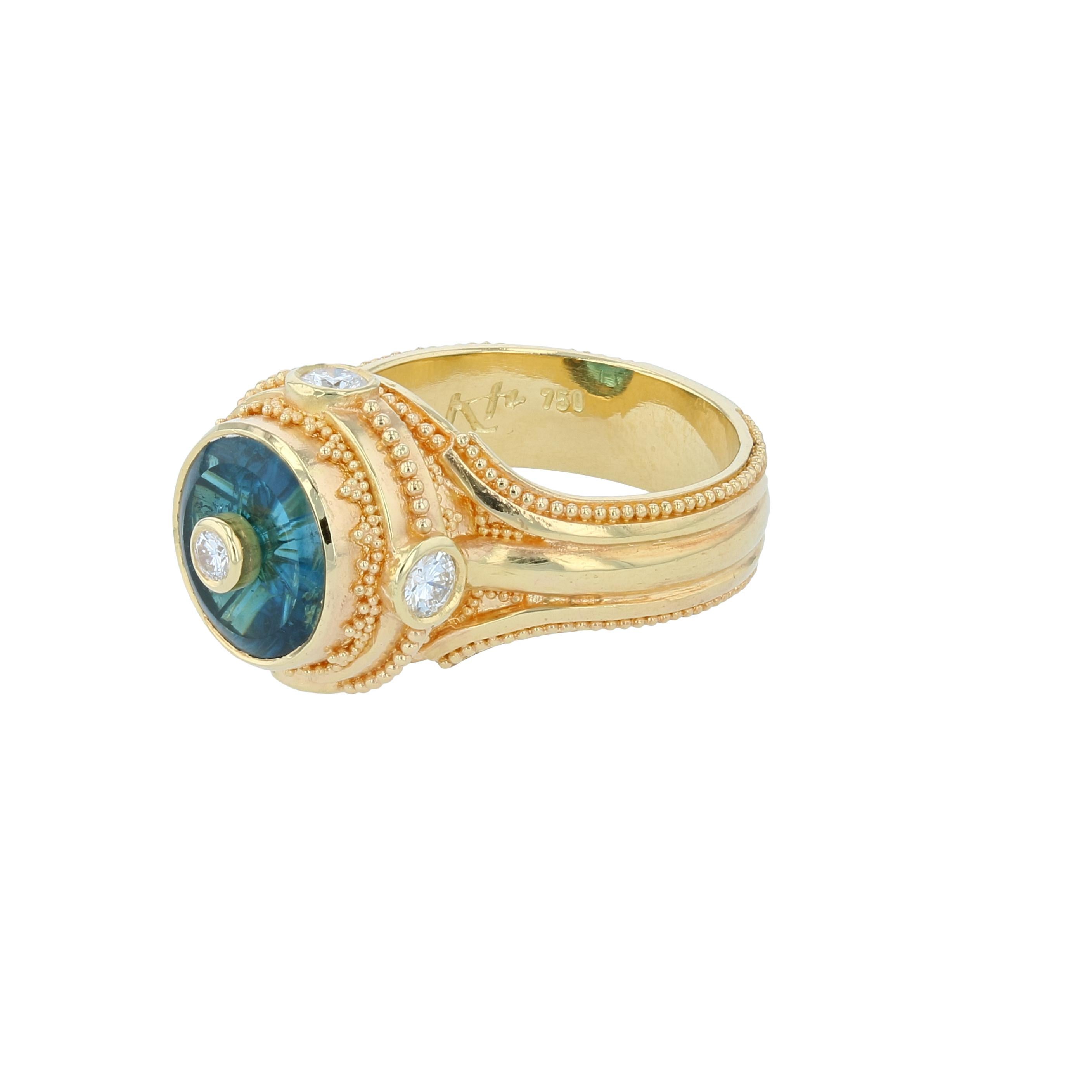 From the Kent Raible limited edition Studio Collection, we present the Prayer Wheel Ring.

The vivid Indicolite (blue-green) Tourmaline 'Torus' was cut by master gem carver Glenn Lehrer. The faceting is all cut on the underside of the gem creating a