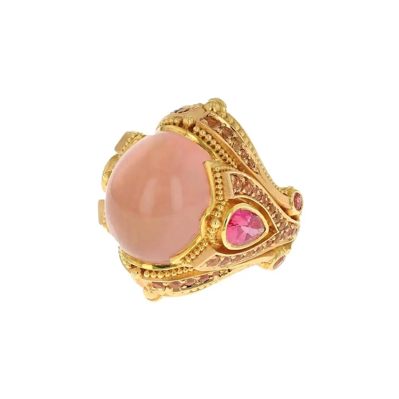 Kent Raible's 'Wish Upon A Star' ring features a 17.78ct Madagascar Star Rose Quartz, 1.55ct Umba River Natural Peach Sapphires and 2.12ct Natural Fuchsia Spinels. 
The main body of the ring was hand fabricated in 18 karat yellow gold, with 18 karat