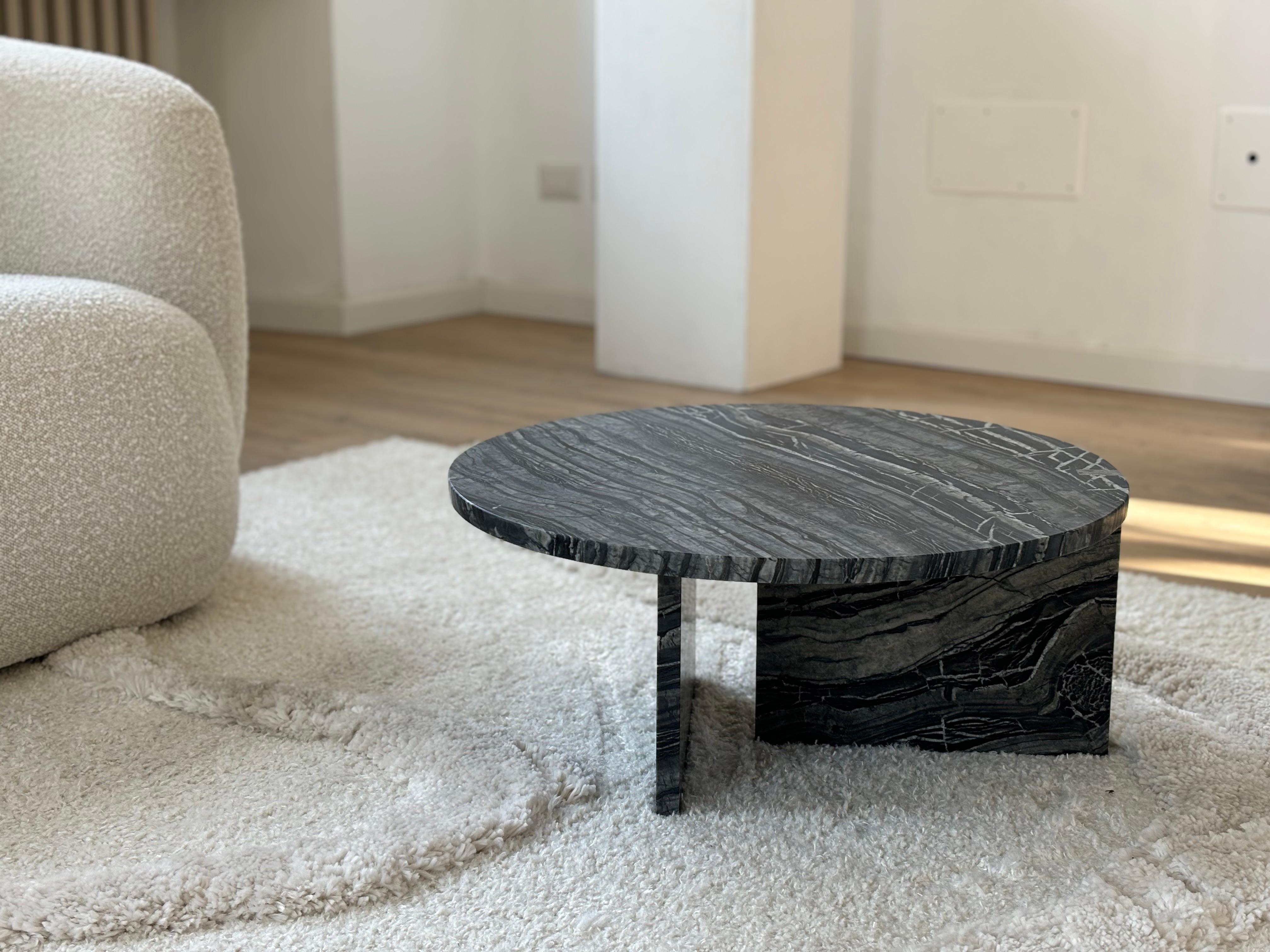 The Hashi coffee table is made entirely of precious Kenya black marble. 

The top is circular and 60 cm in diameter, the legs are made from two marble boards in which one part is inlaid on the top as a very elegant detail.
Artisanal production made