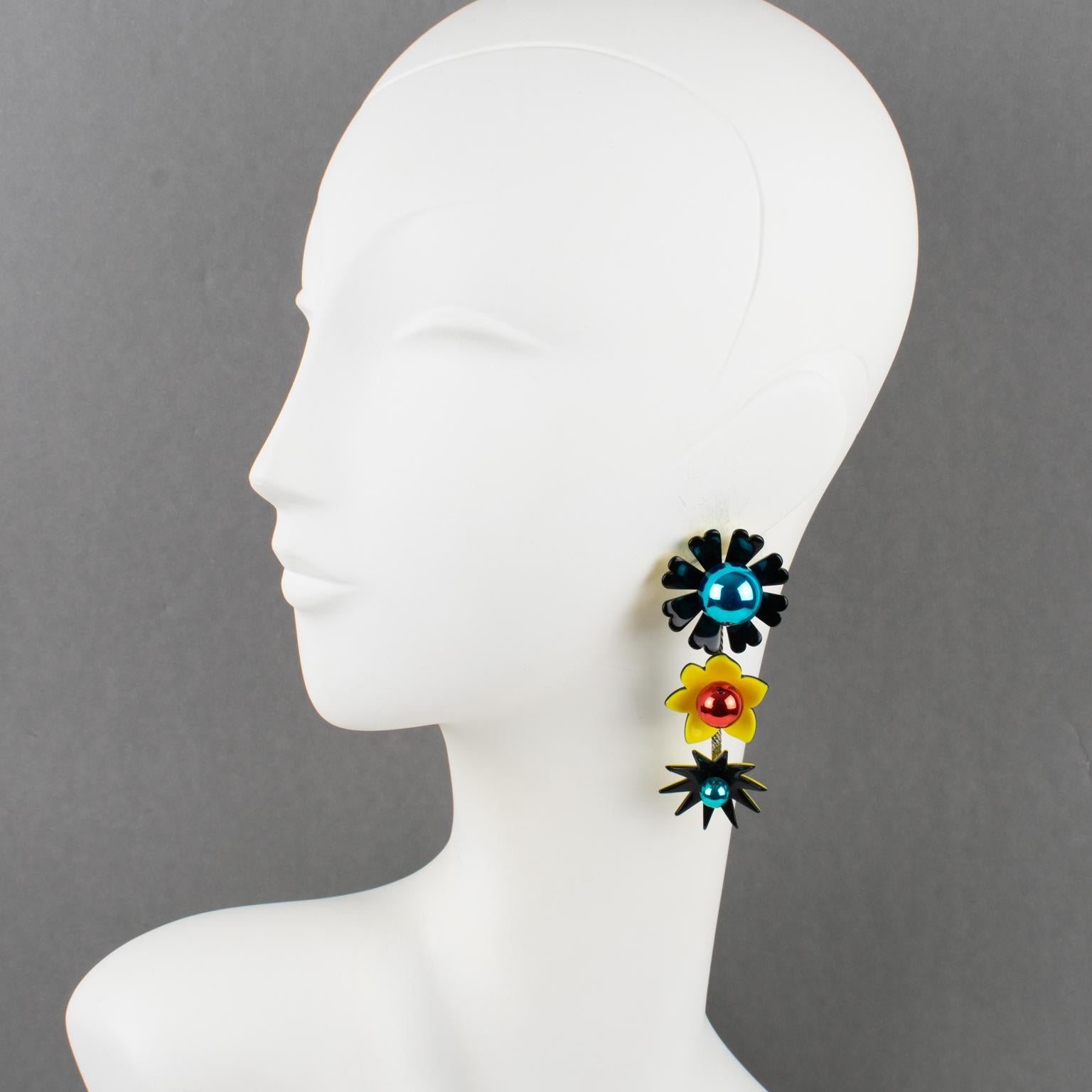 These stunning Kenzo Paris resin and glass pierced earrings feature a long dangling drop shape with a floral design built with black and yellow acrylic. The flowers are embellished with a mirrored glass bead in turquoise blue and bright red assorted
