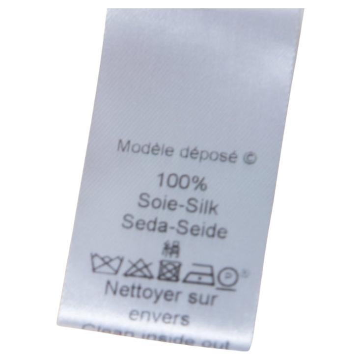 Wie schön sieht diese cremefarbene Bluse von Kenzo aus! Es ist aus 100 % Seide gefertigt und hat eine schicke Silhouette. Es hat einen Halsausschnitt mit Rüschenbesatz, einen Knopfverschluss vorne und lange Ärmel. Kombinieren Sie es mit Jeans und